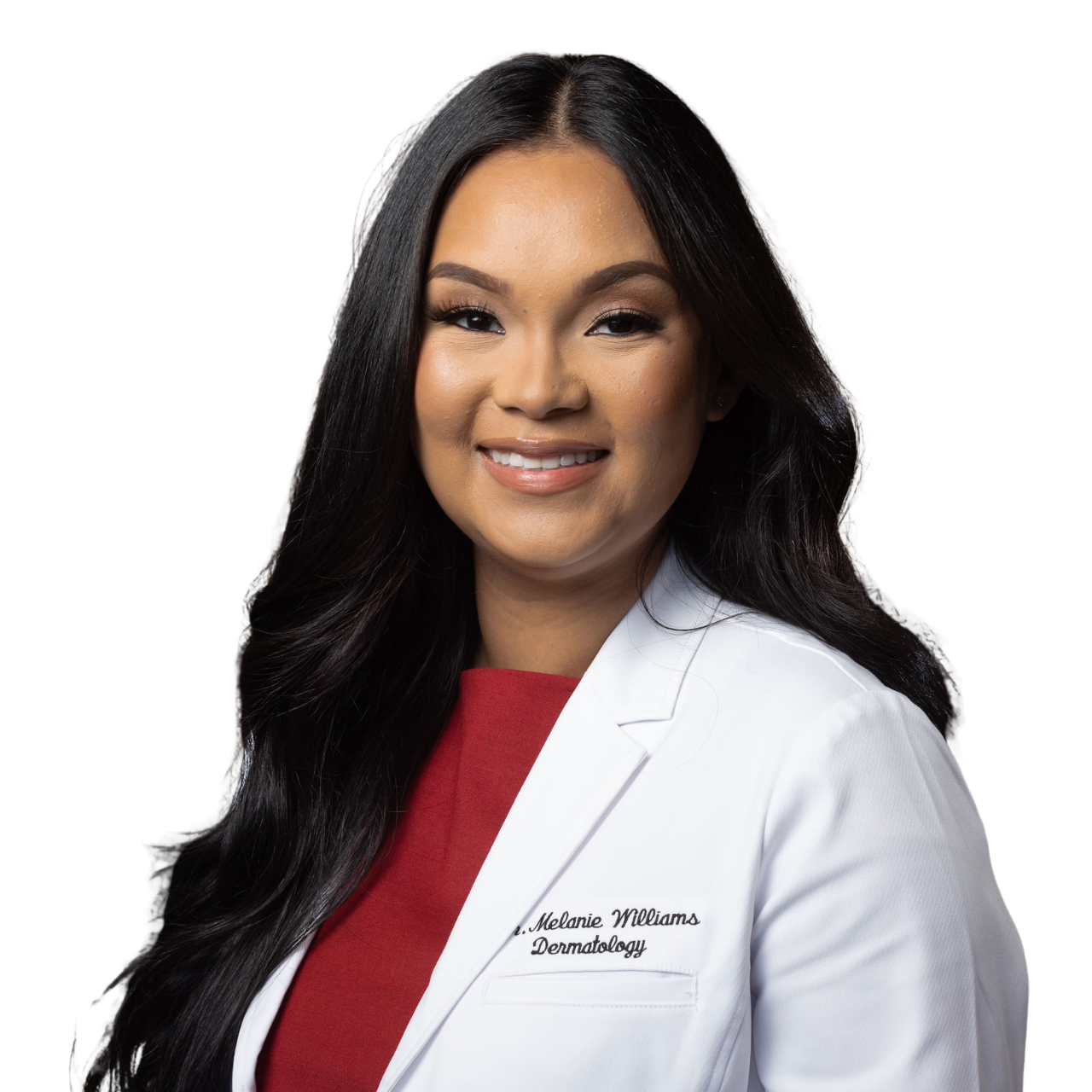 A woman with long dark hair wearing a white lab coat with her name and title embroidered on it, over a red shirt, smiling in a professional setting.