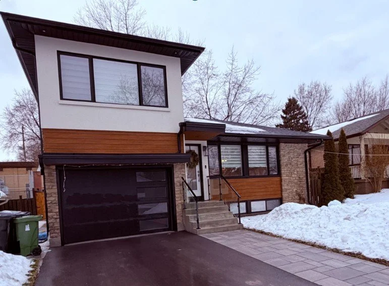   The finished exterior of 10 Wooster Wood — stone, longboard siding, stucco, and a custom garage canopy that required engineering revisions mid-construction to get exactly right  