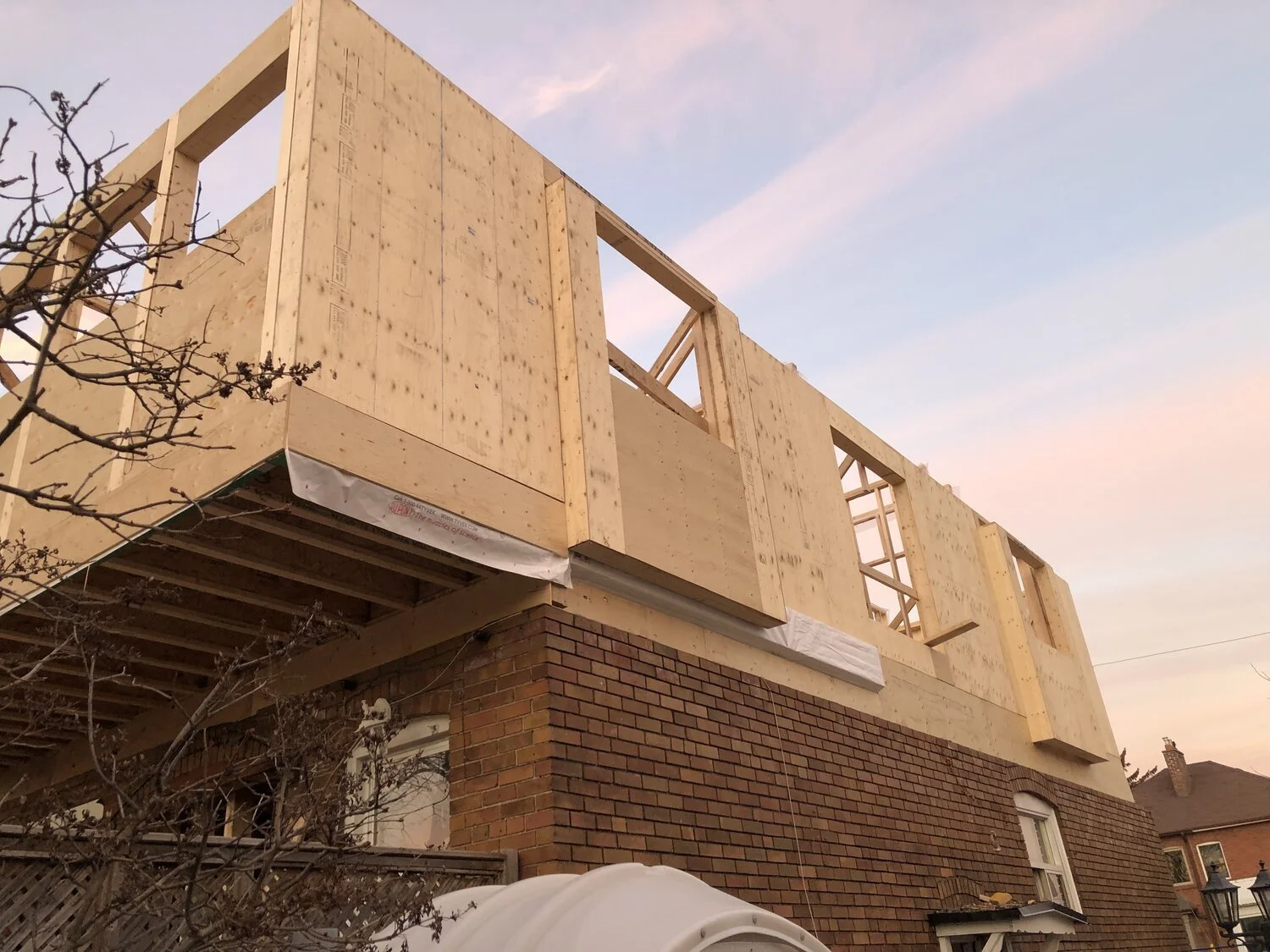 On the left side of this photo you can see the cantilever of the second floor system (located at one of our project sites in Toronto) out from the back wall of the bungalow. The joists are still exposed in this shot which gives a nice view of how the framing looks.