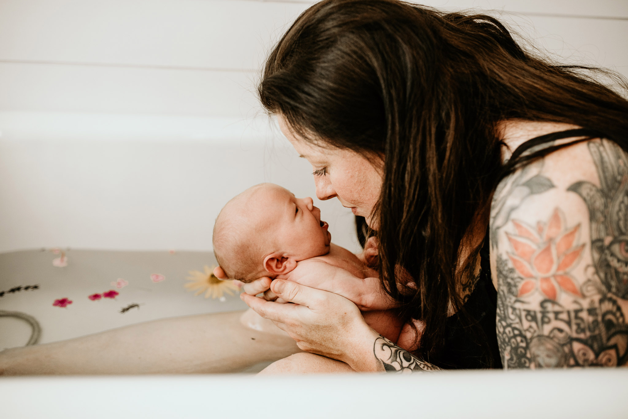 Mother and baby in bathtub with flowers