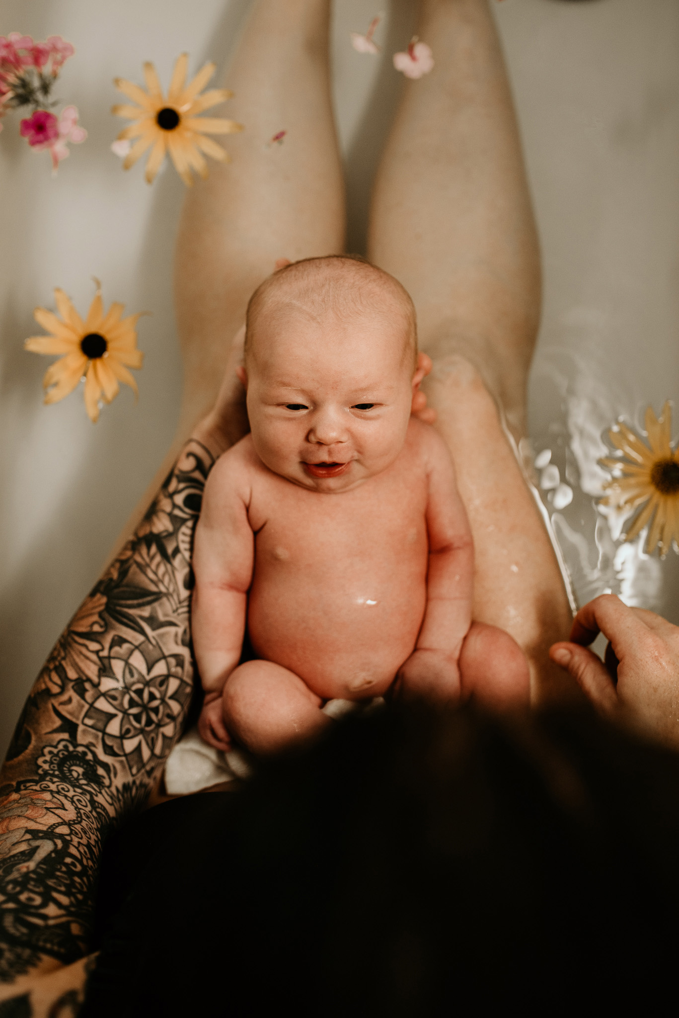 Newborn baby with mother bathtub flowers