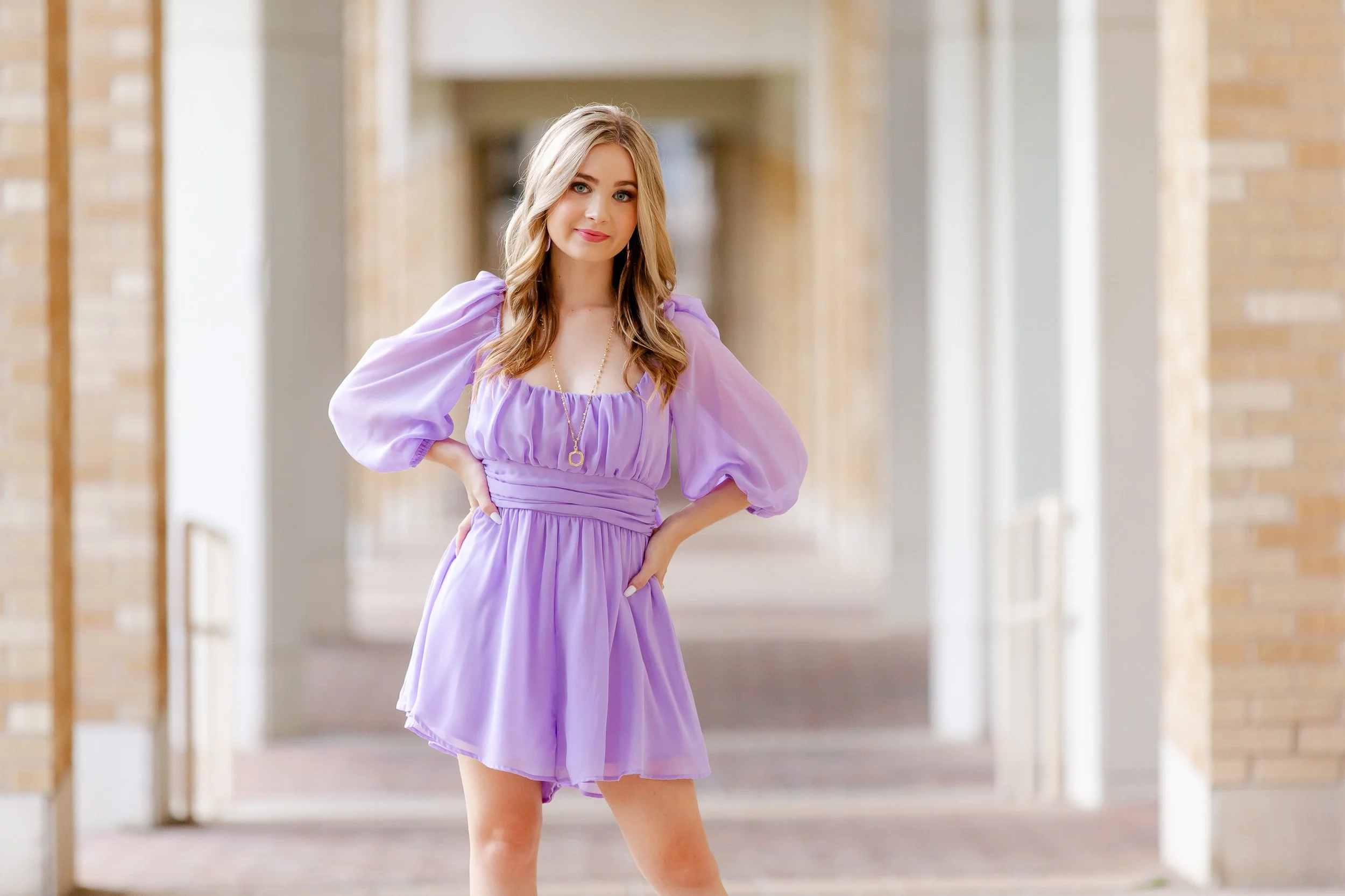 TCU senior girl in lavender dress holding cords during Fort Worth senior portraits