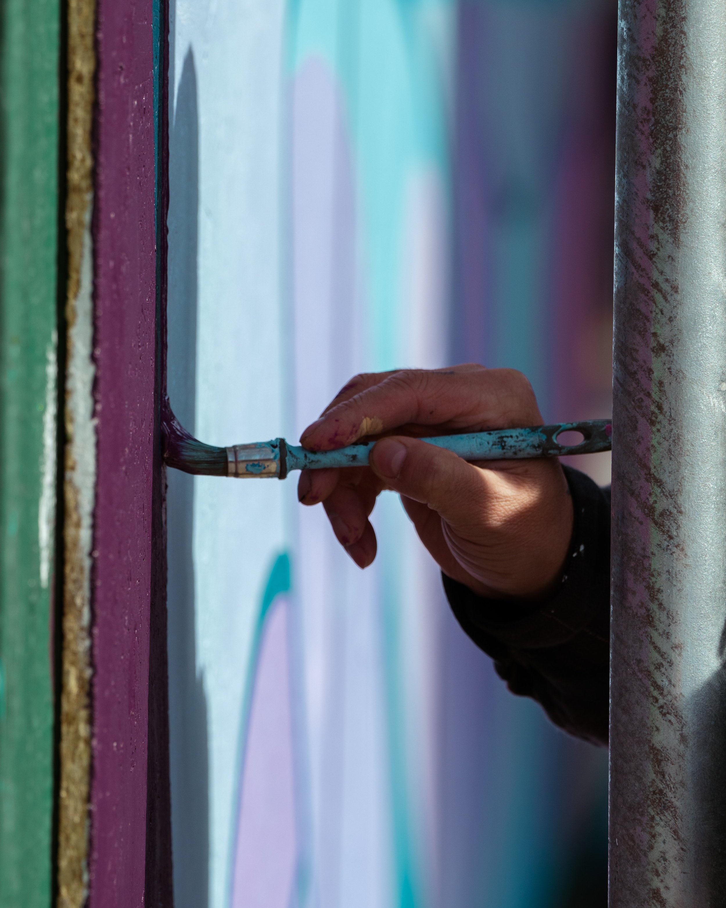  Close-up view of a paintbrush as artists complete the Nunatta Atuagaateqarfia mural project as part-of the Nuuk Nordic Festival. Nuuk, Greenland. May 2023. Photograph: Bronson Jacque. 
