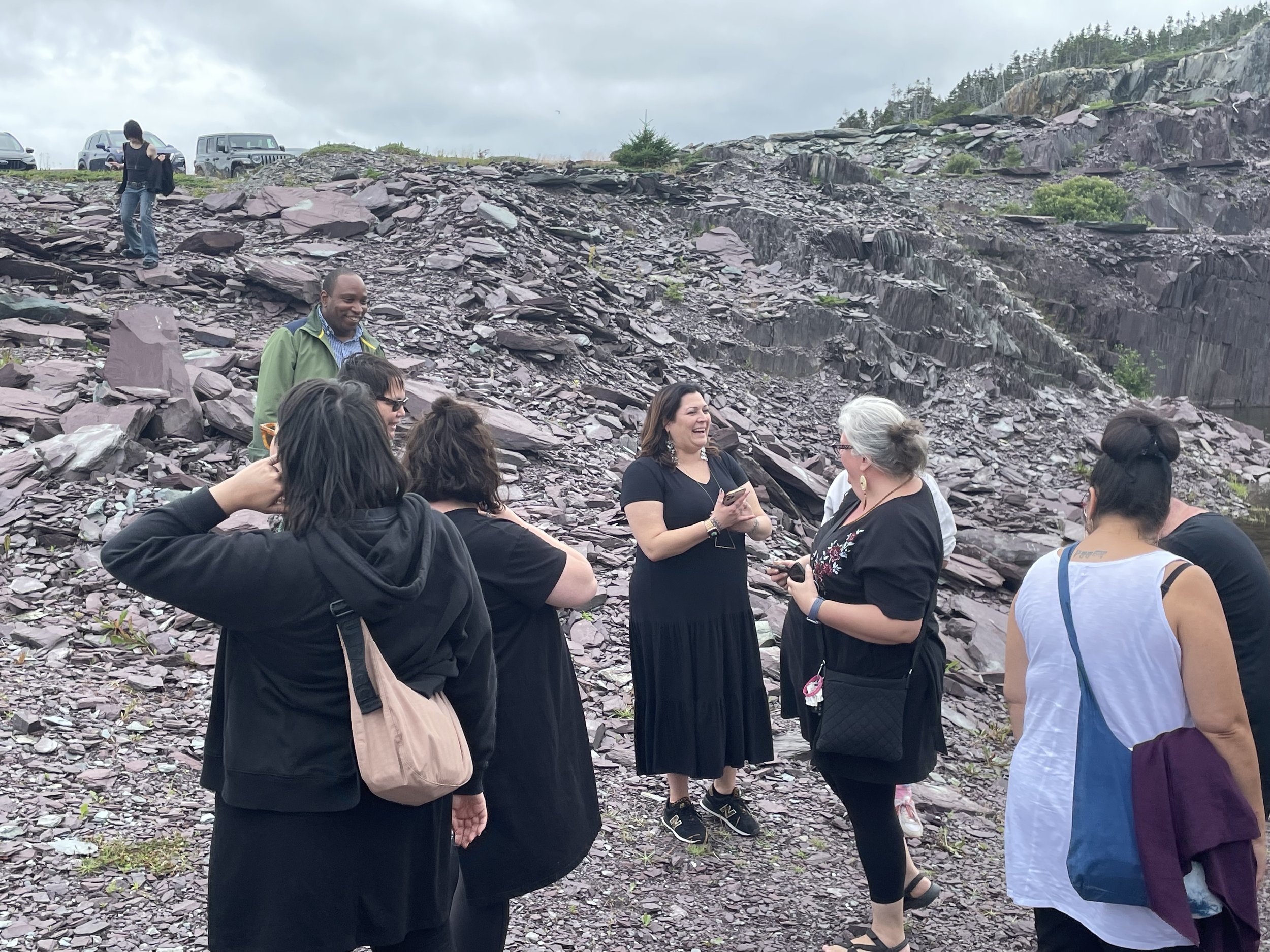  Dr. Heather Igloliorte talks with other participants by the work of SK Weston at the Bonavista Biennale, August 2023. Bonavista, NL. Photograph by Danielle Miles. 