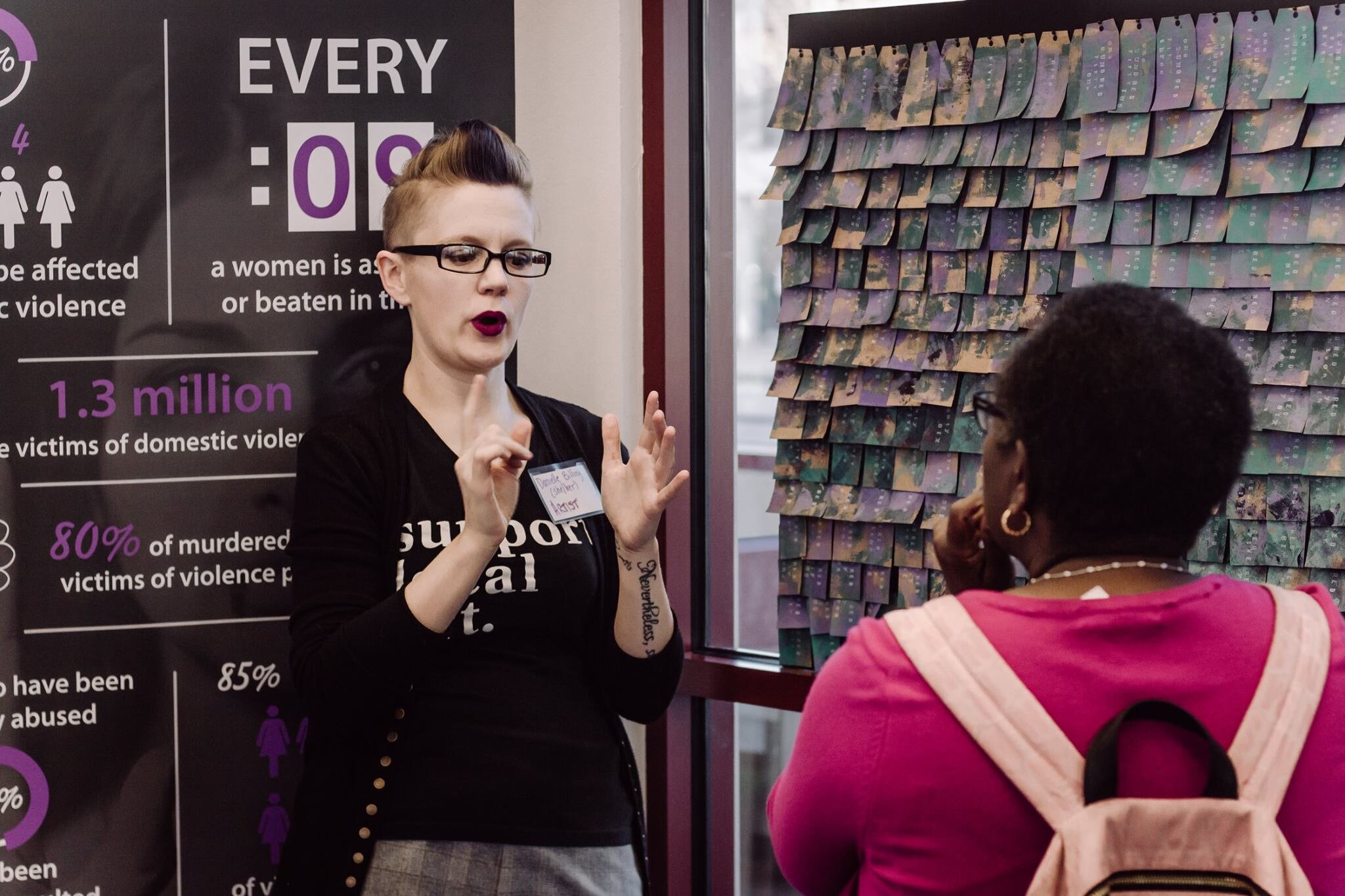 Conversing with a Deaf colleague at the UnSilenced pop-up gallery.