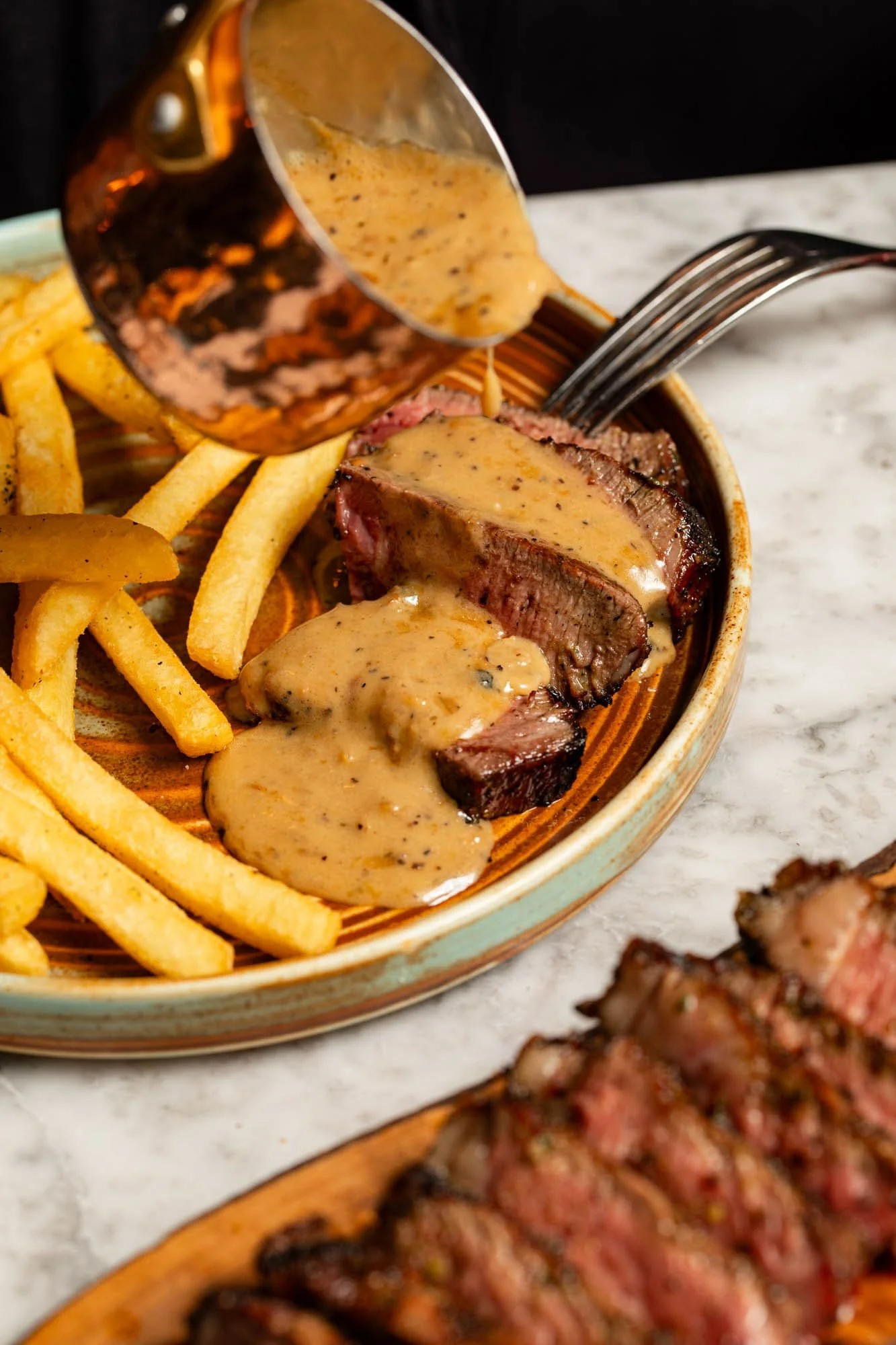 Peppercorn sauce poured over a steak