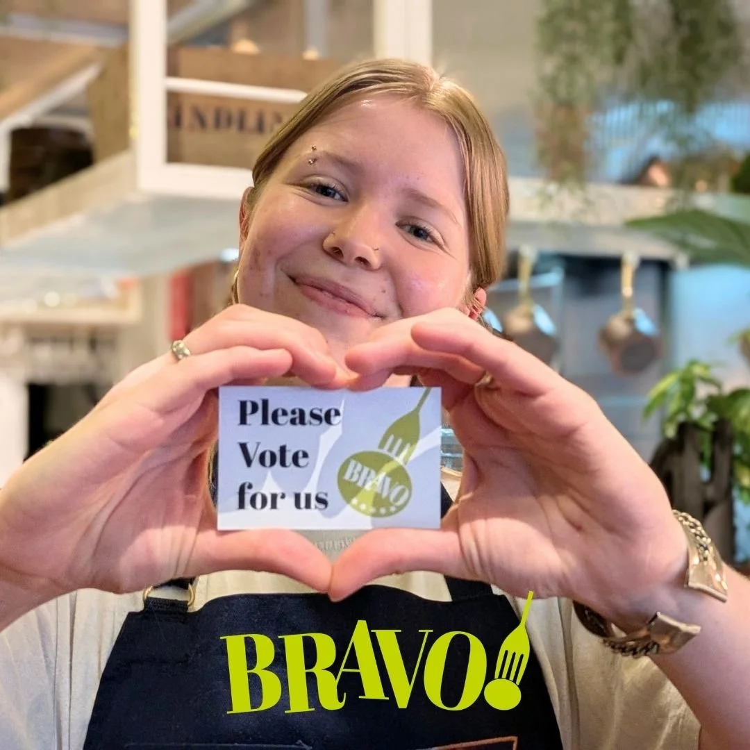 Kindling team member holding up a card which says Please vote for us
