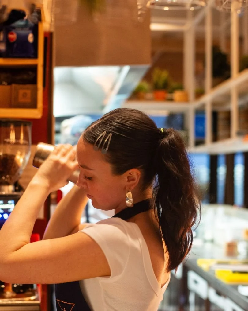 A person shaking a cocktail shaker at Kindling restaurant