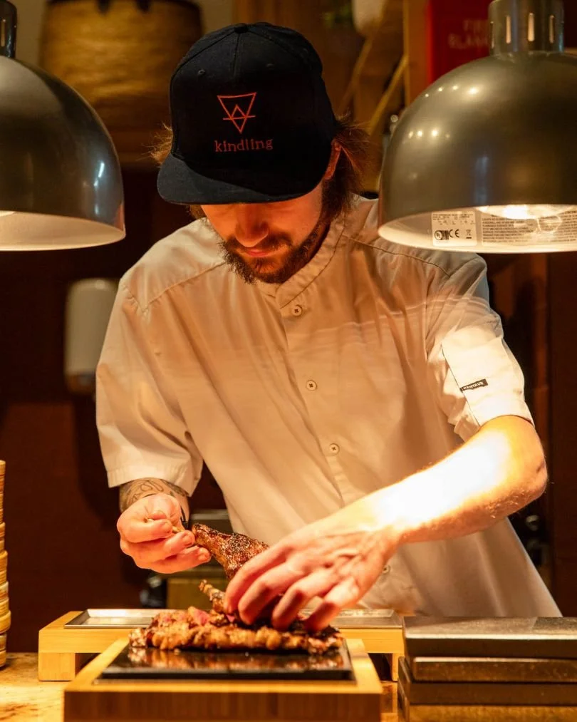 Chef at Kindling plating a mid-week meat platter