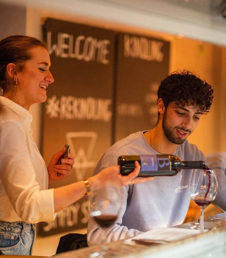 A waiter pouring red wine