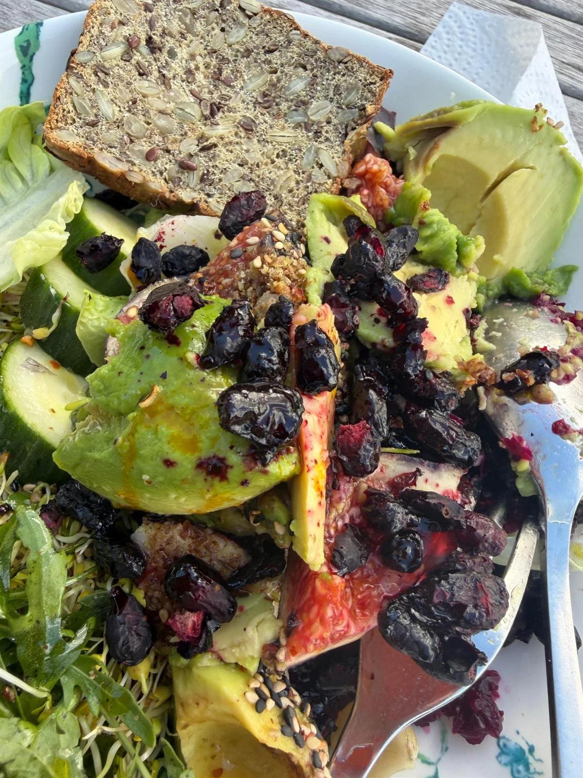 Rocket salad with cucumber figs feta cheese walnut avocado and honeyberries