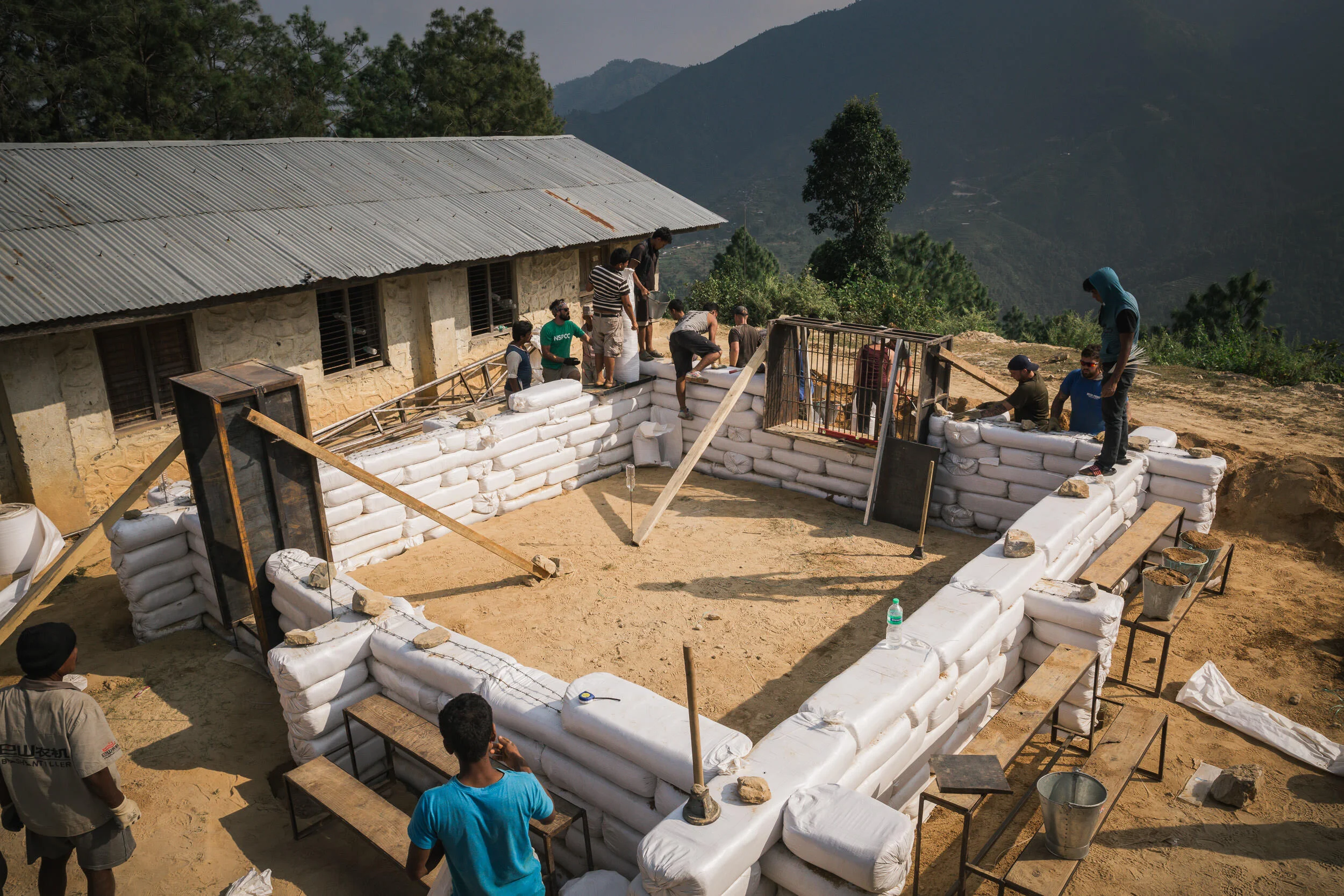  Palchok, Nepal - The walls of a new classroom are erected using rice bags filled with clay sourced from nearby. Photographed by Philipp Ammon for Worldwide Action 