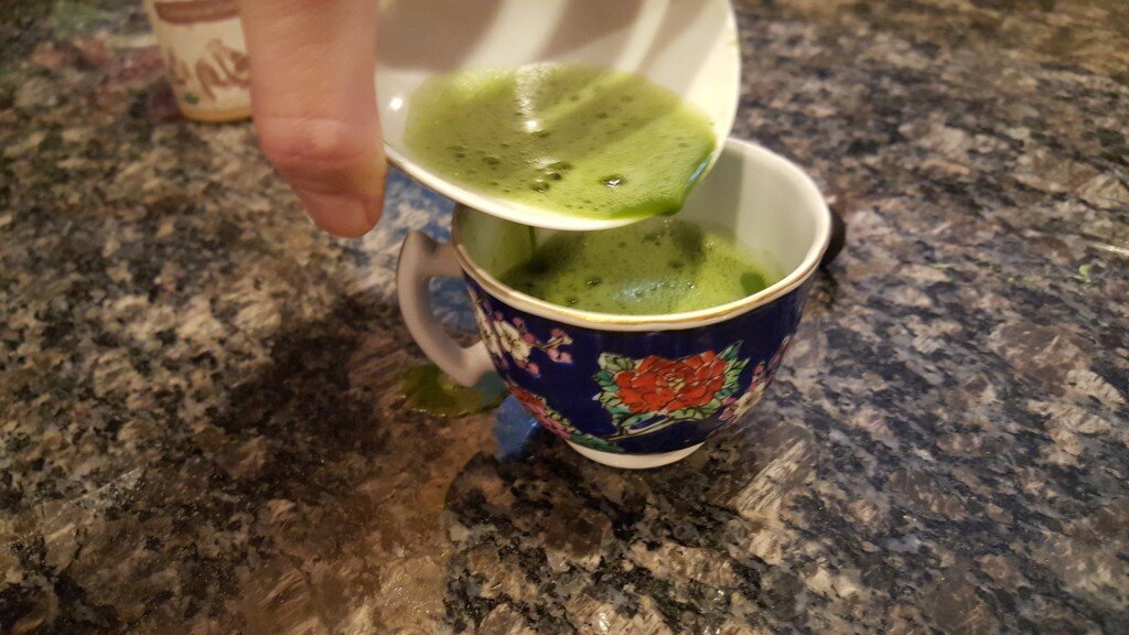 Frothy Matcha Tea being poured into blue floral teacup
