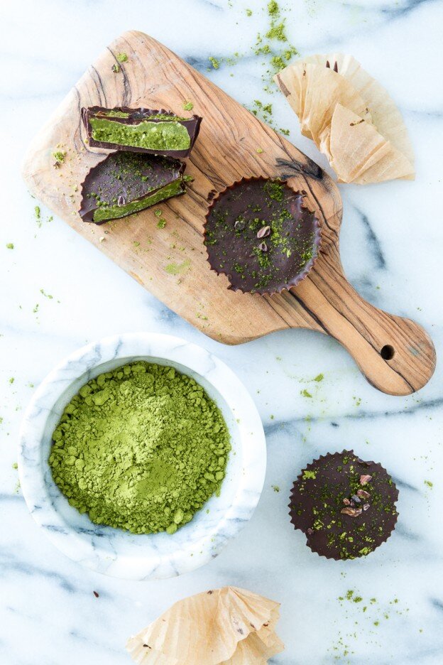 Chocolate Matcha Butter Cups on Cutting Board, next to big bowl of Matcha Powder