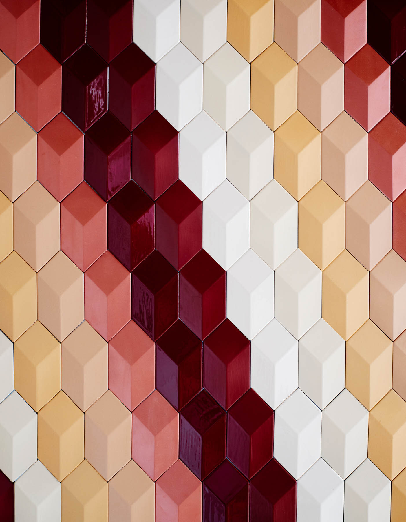 Wall with clay tiles in format rombo 3D glazed with 'Bordeaux Shiny Crystal' and 'Red Sea Matt'