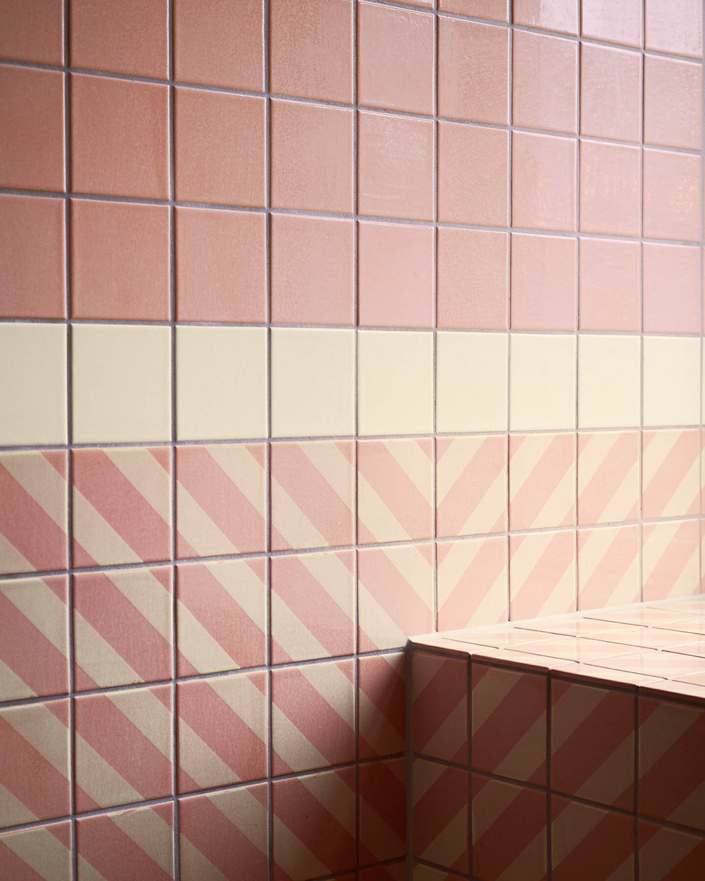 Bathroom wall with clay tiles in format 10x10x1 cm glazed with 'Dark Pink Champagne Matt'