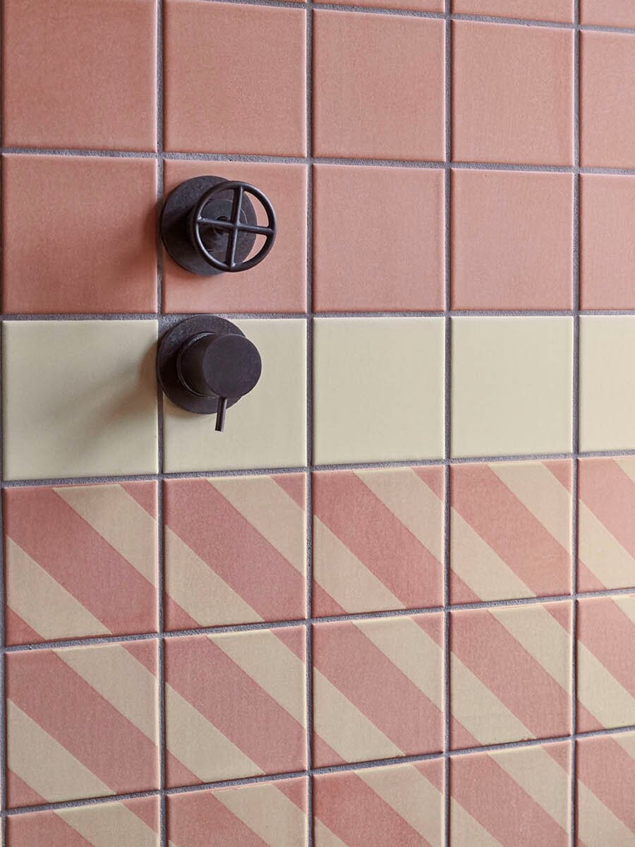 Bathroom wall with clay tiles in format 10x10x1 cm glazed with 'Dark Pink Champagne Matt'