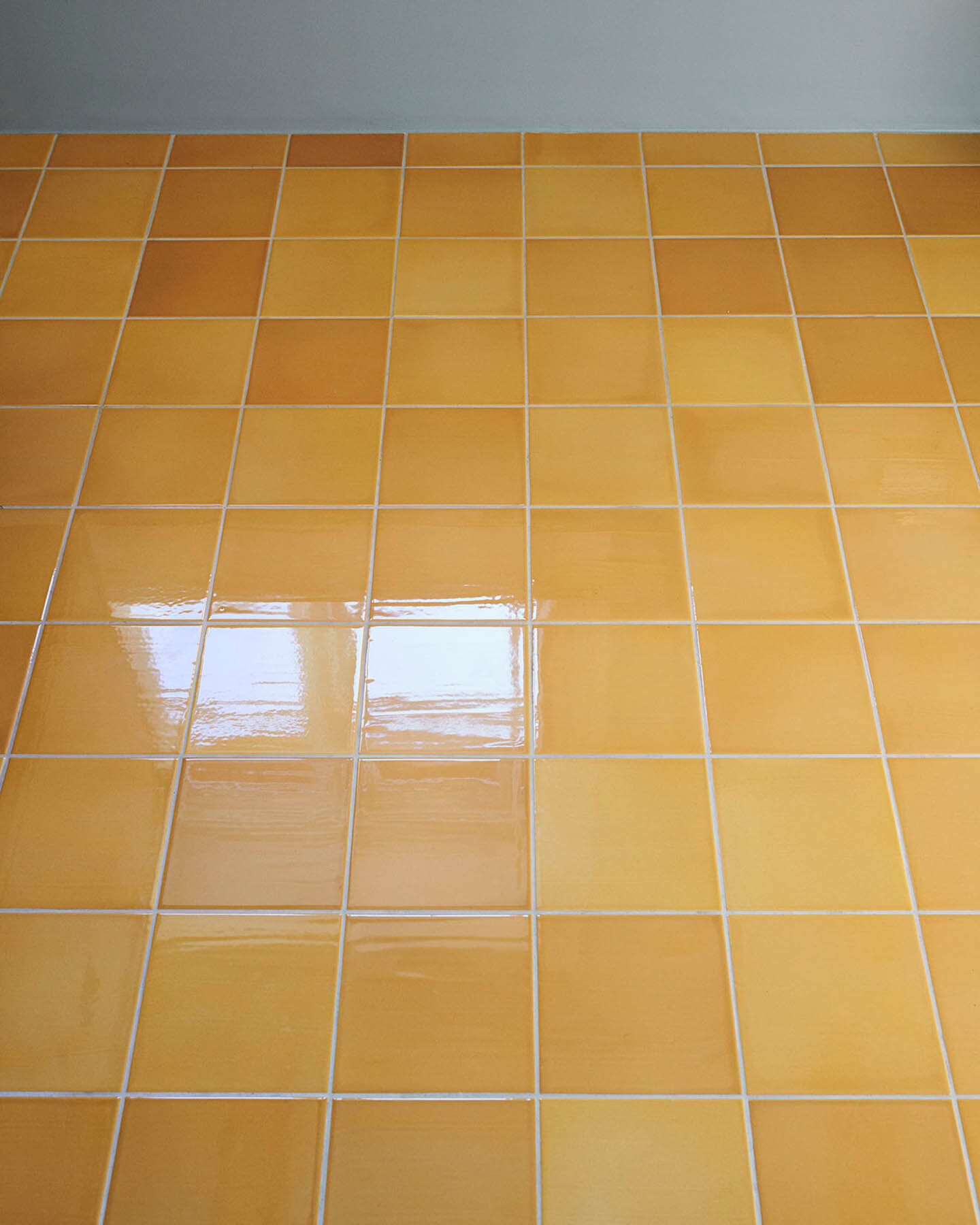 Floor with clay tiles in format 15x15x1 cm glazed with 'Submarine Shiny Crystal'