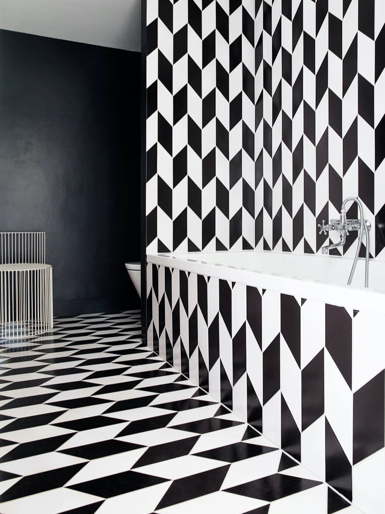 Bathroom floor and wall with clay tiles in chevron patchwork glazed with 'Black Swan Matt' 