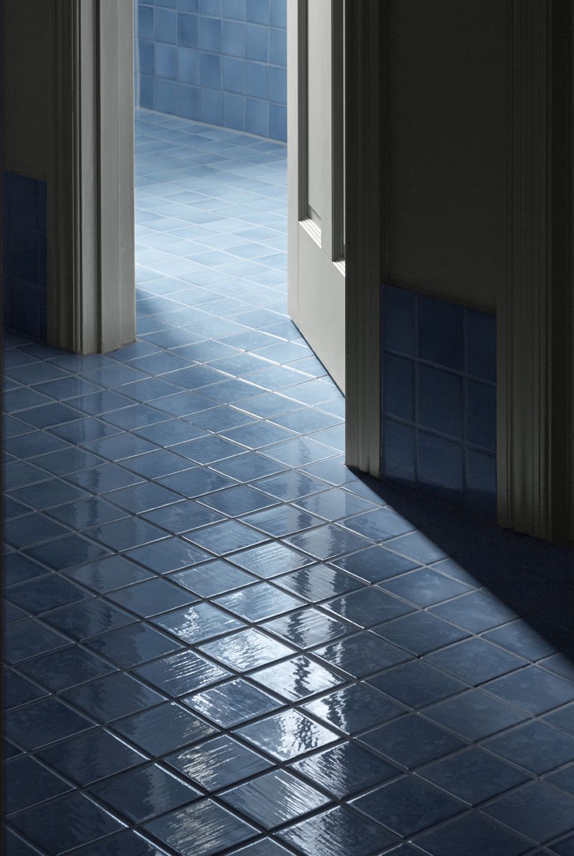 Floor with clay tiles in format 10x10x1 cm glazed with 'Blue Smoke Shiny Crystal'