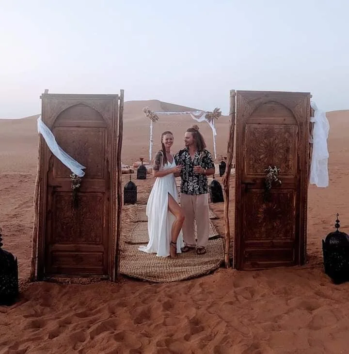 a bride and a bridegroom in their day of marriage planned in a camp in the middle of sahra desert
