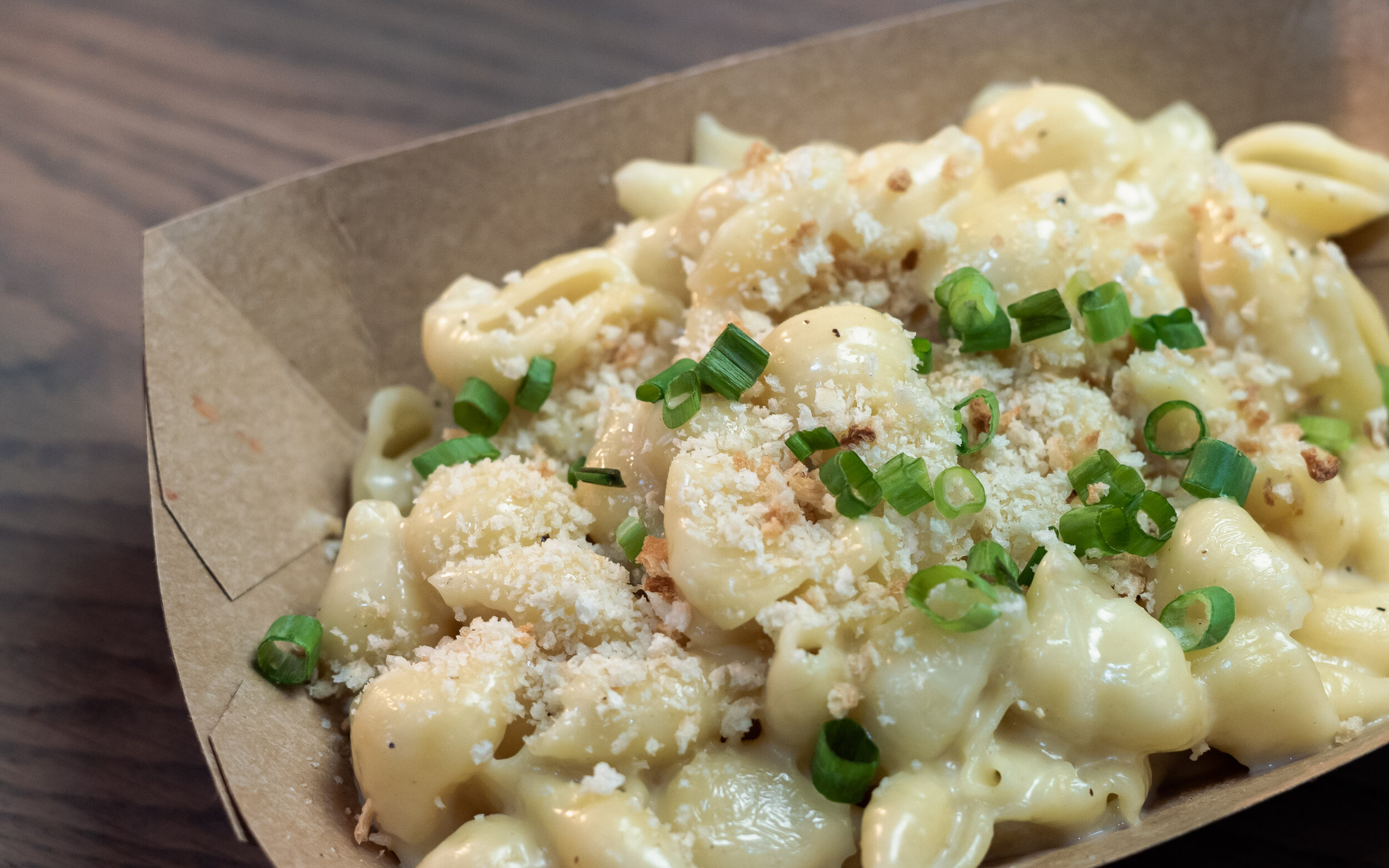 bowl of macaroni and cheese topped with green onion