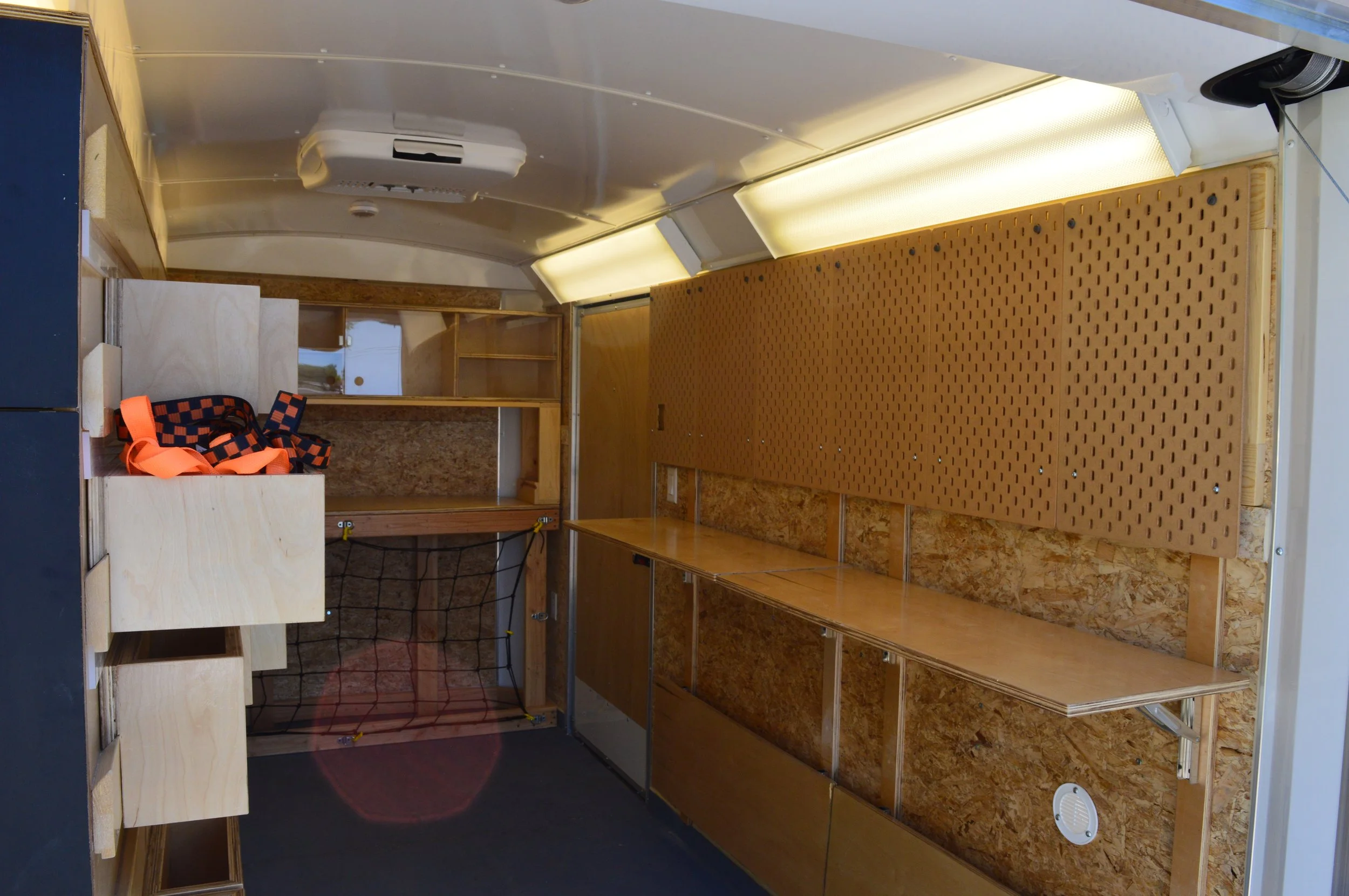  This side of the trailer is lined with folding desks and pegboards for storage and display 