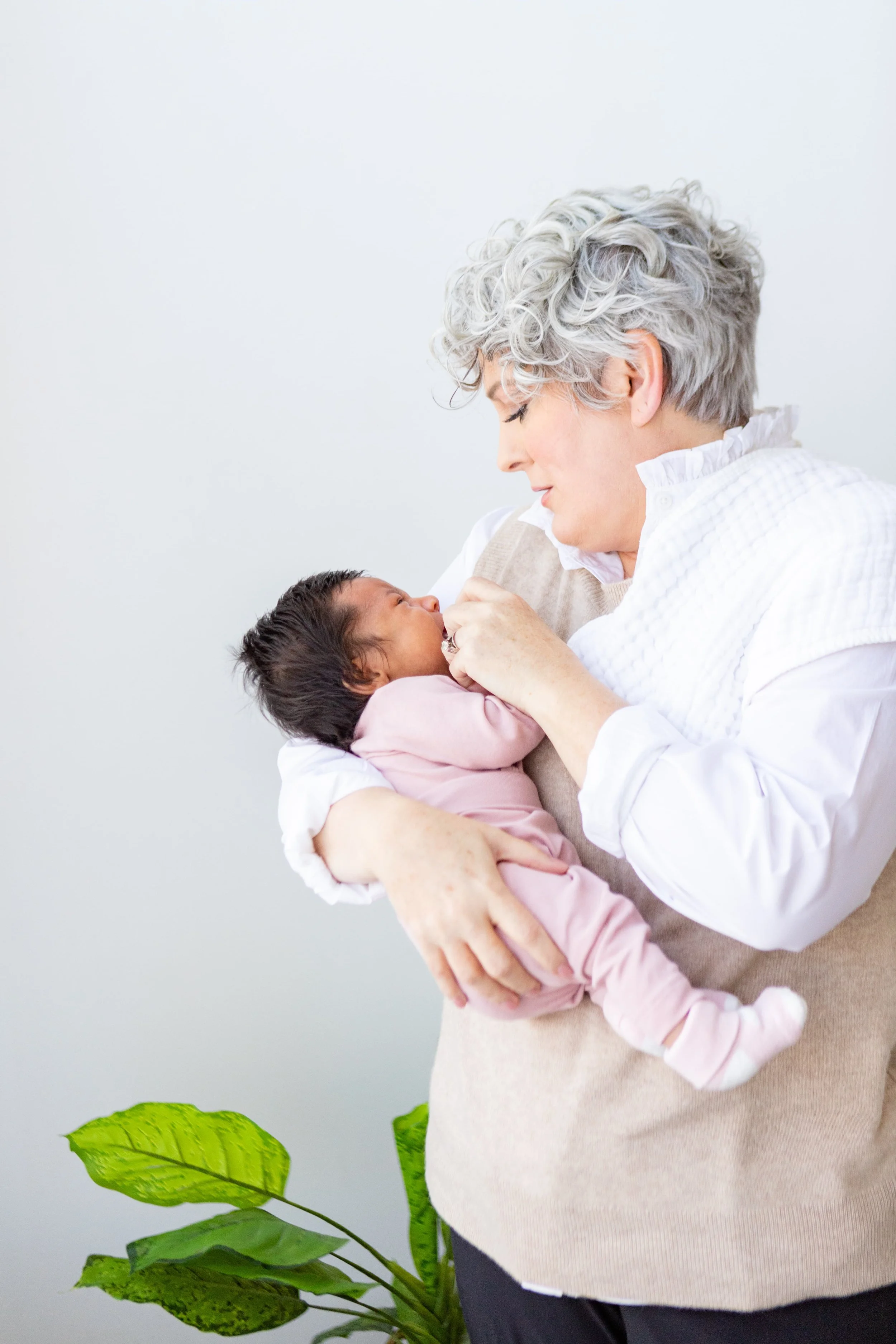 A newborn is held and soothed by a night nanny from The Hive Nanny Agency in Utah.