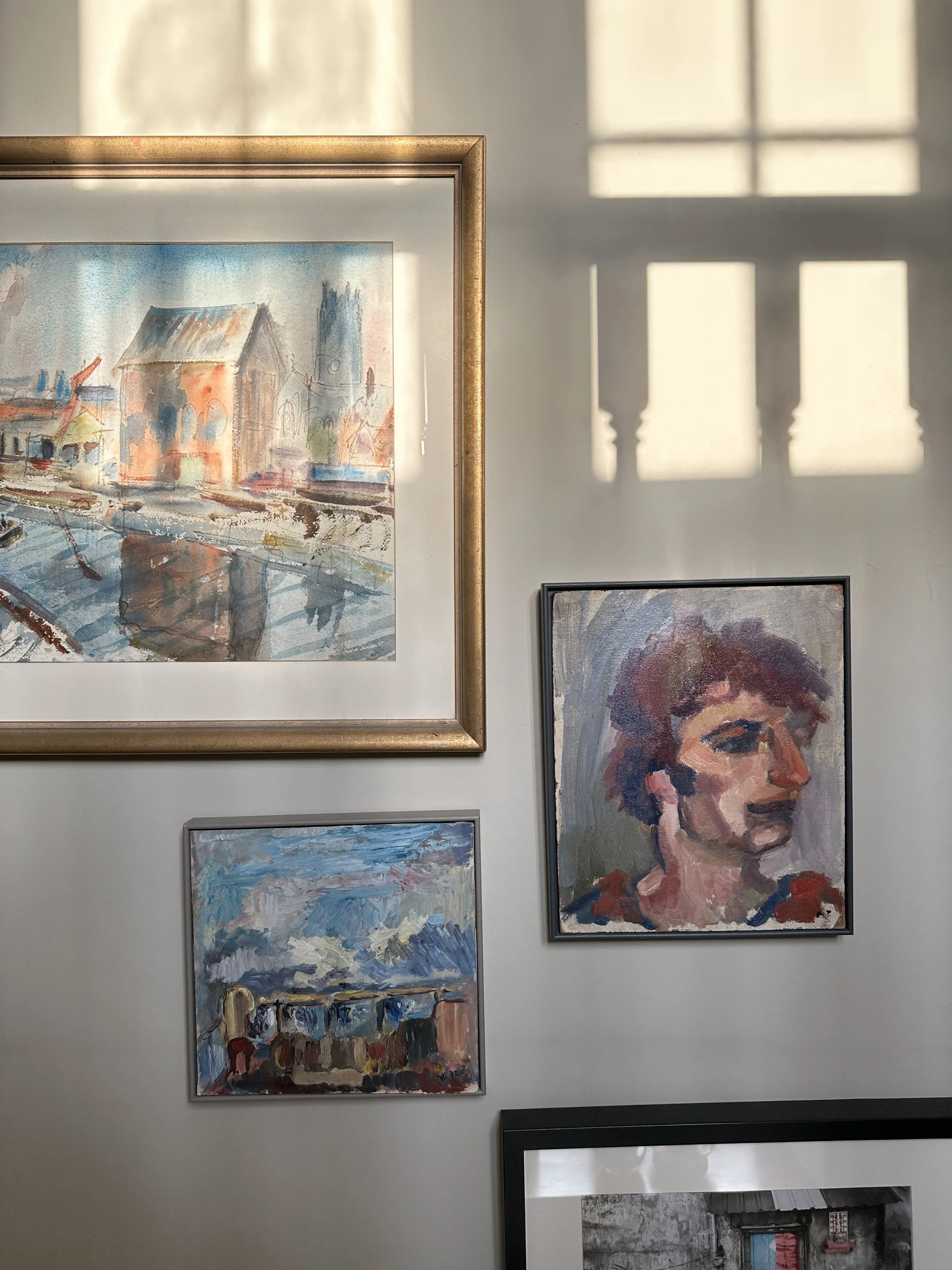 Collection of framed artwork displayed in soft natural light.