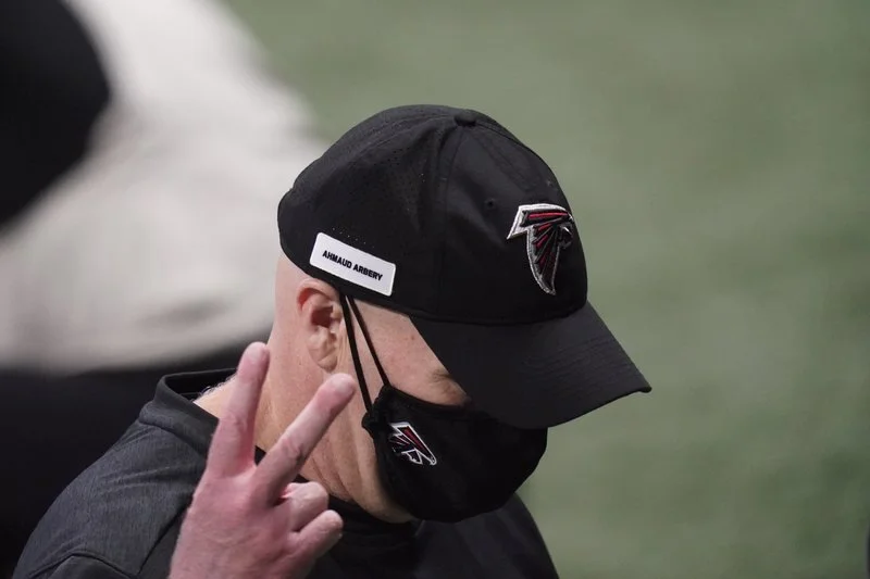  Atlanta Falcons head coach Dan Quinn gestures a peace sign as he walks off the field after an NFL football game against the Carolina Panthers on Sunday in Atlanta (Bryan Anderson/AP Photo). 
