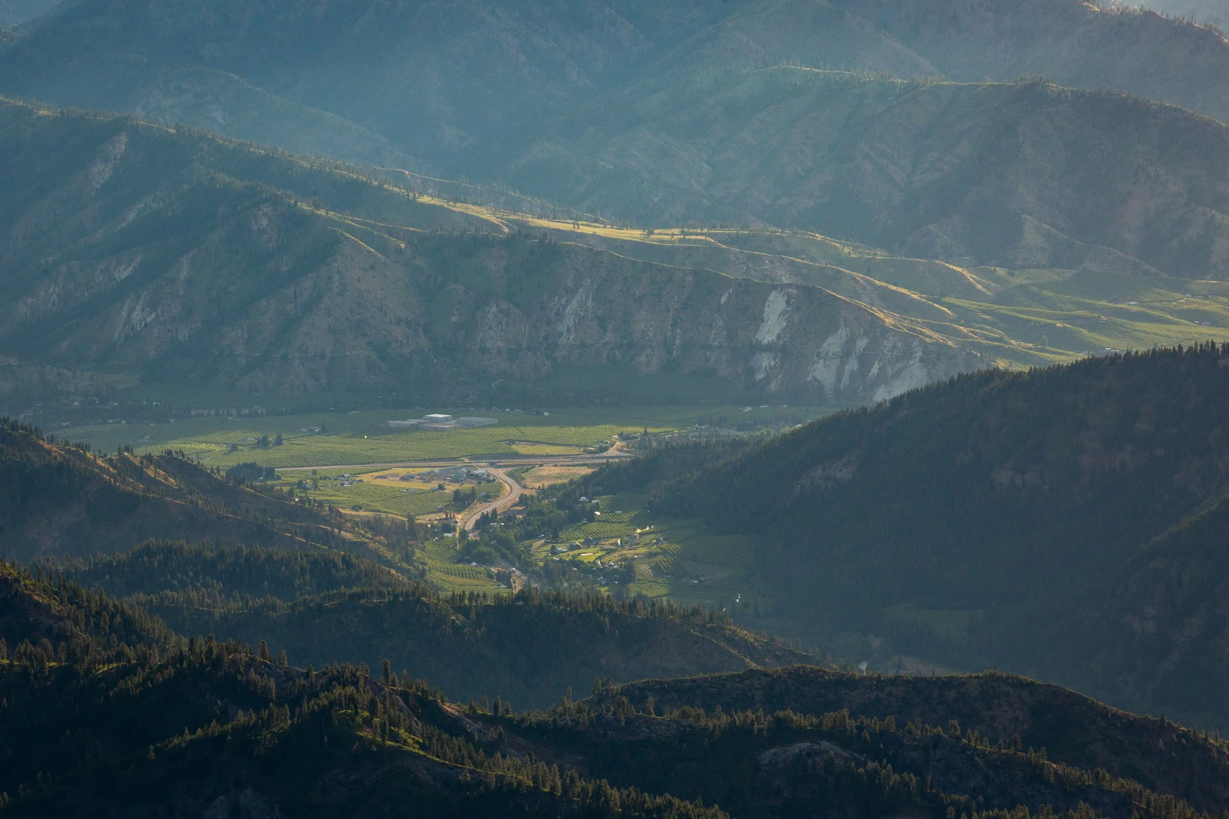 Mountain landscape with green valleys and winding roads.