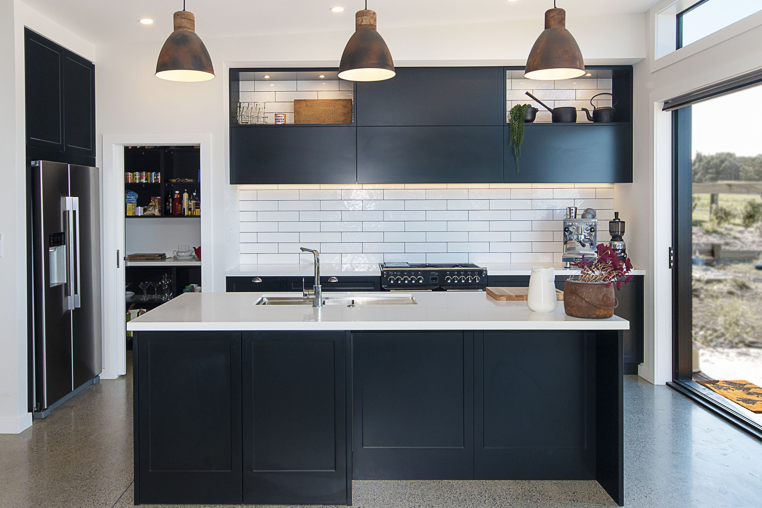 This open plan kitchen takes advantage of the stunning water views. The shaker cabinetry, subway tile and range cooker add to the kitchens character
