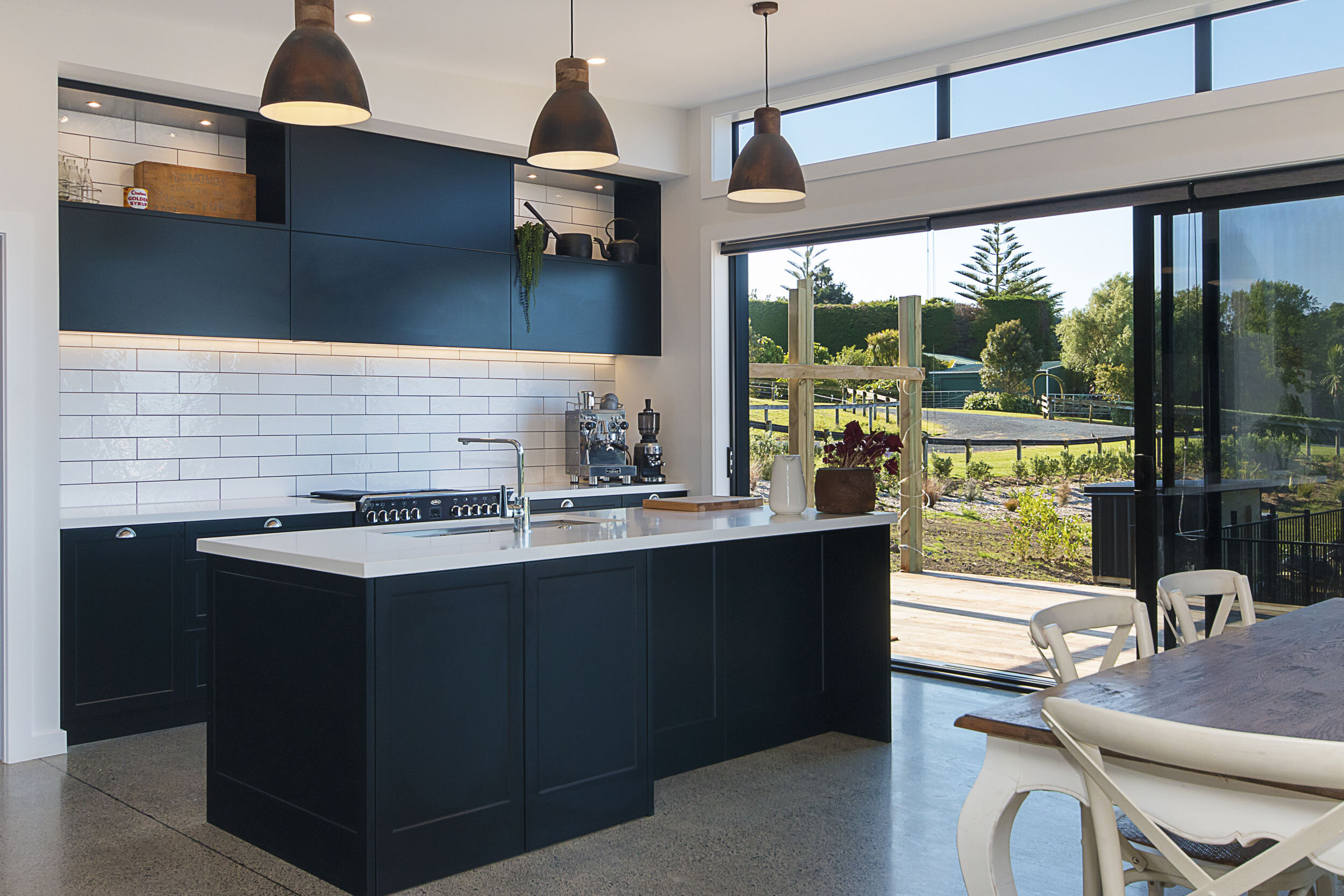 Great contemporary country kitchen inspiration - black shaker cabinetry, white bench tops and white subway tile