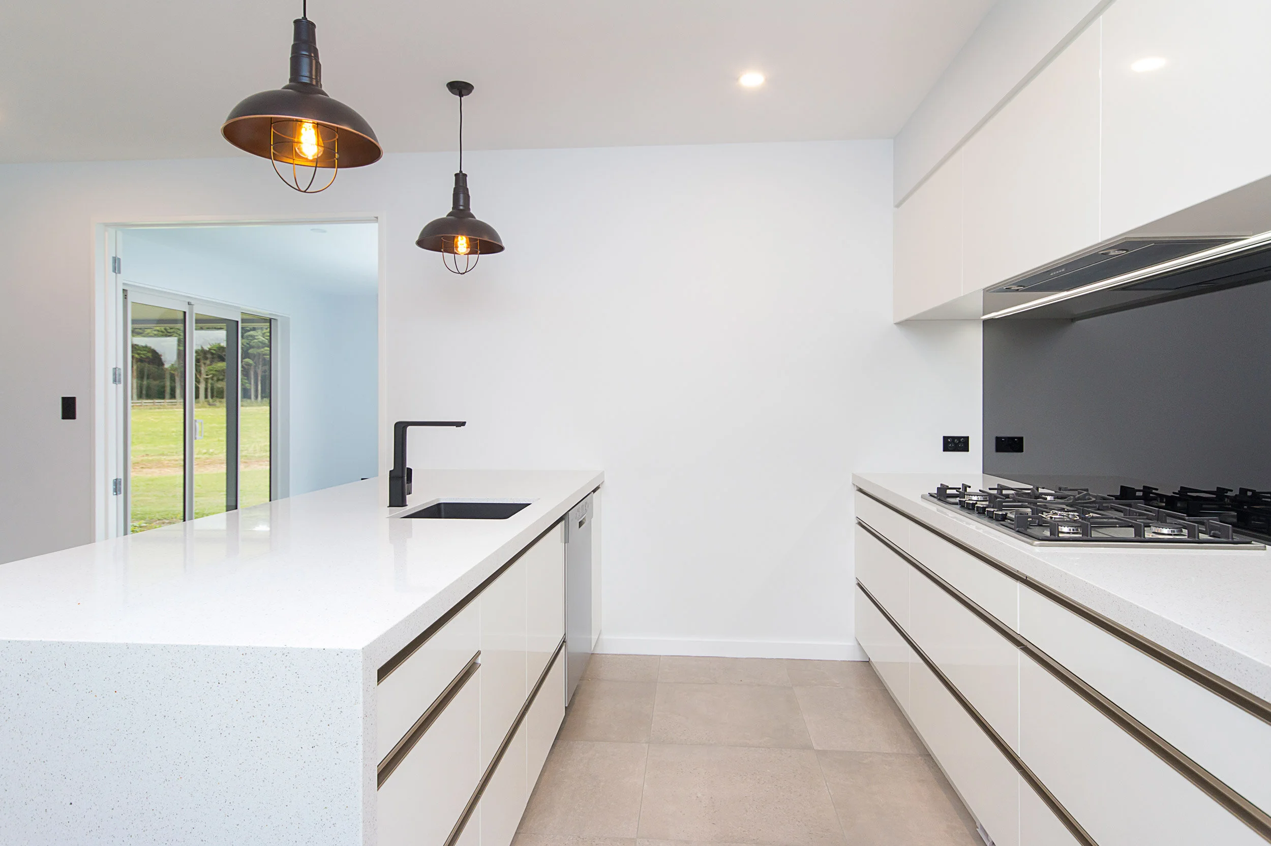 Modern white kitchen with black splashback