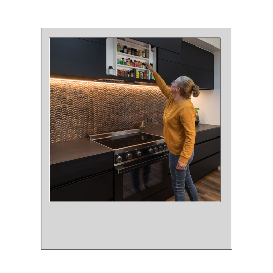 Woman in kitchen reaching for item on shelf