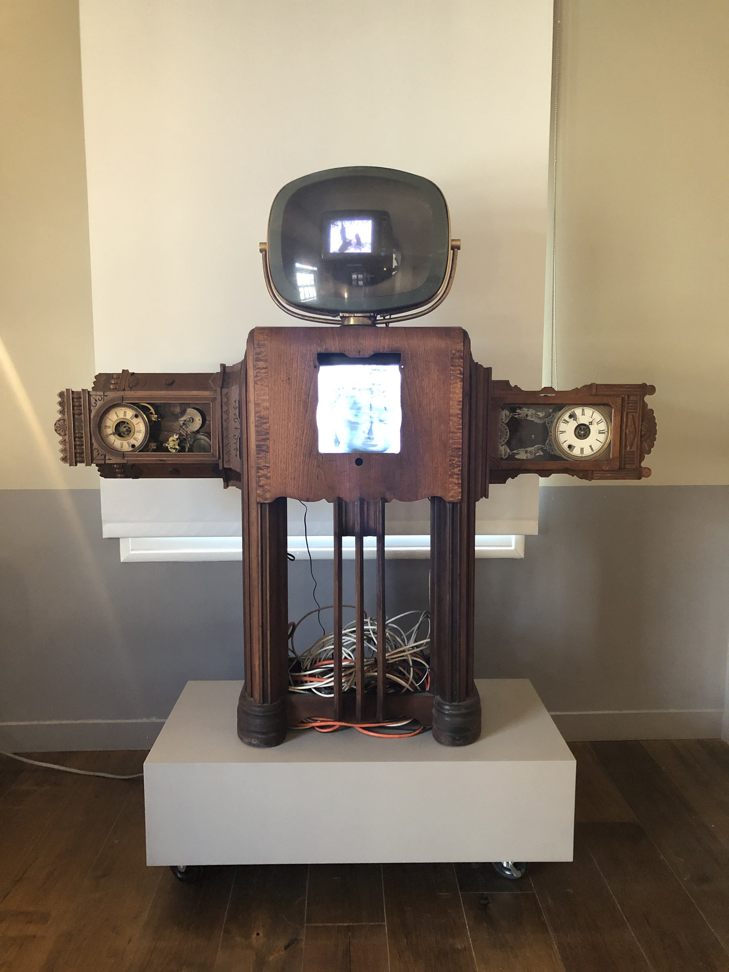  Nam June Paik,  Clock Arms Robot , 1995. Antique TV cabinet, antique clocks, two channel video and two video monitors. 72 x 61 x 21 inches.&nbsp;Installation at Felix Art Fair, 2020.  
