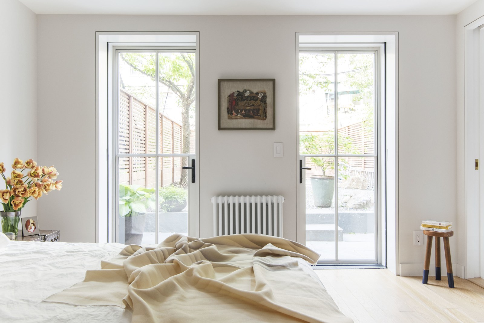  The steel and glass doors in the serene downstairs master bedroom are a simpler version of the ones on the parlor level. "They have that really thin profile to give you as much glass as possible," says Roberts. Save for the door handles, all of the 