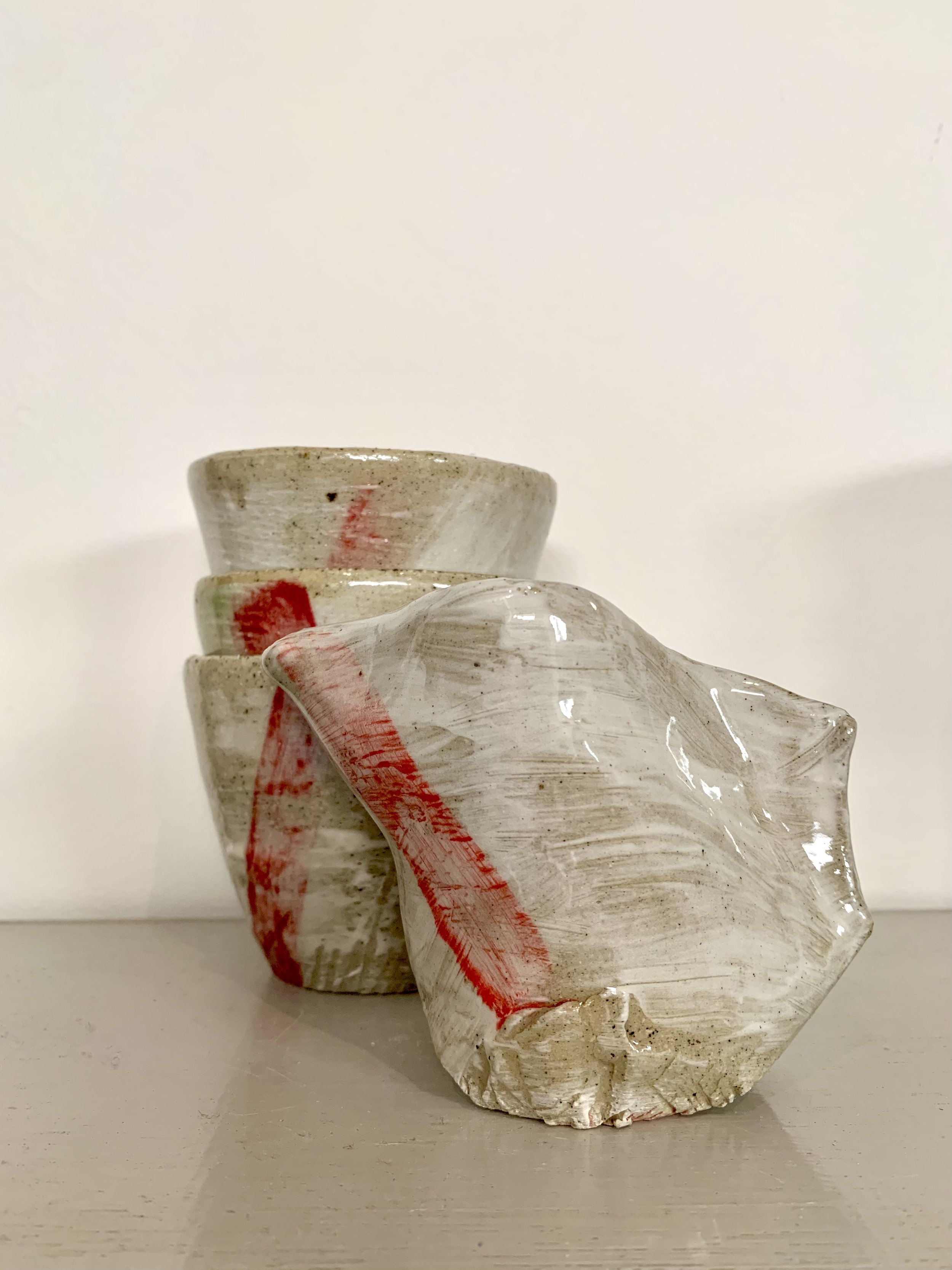 Three slip decorated and carved stoneware tumblers and pourer