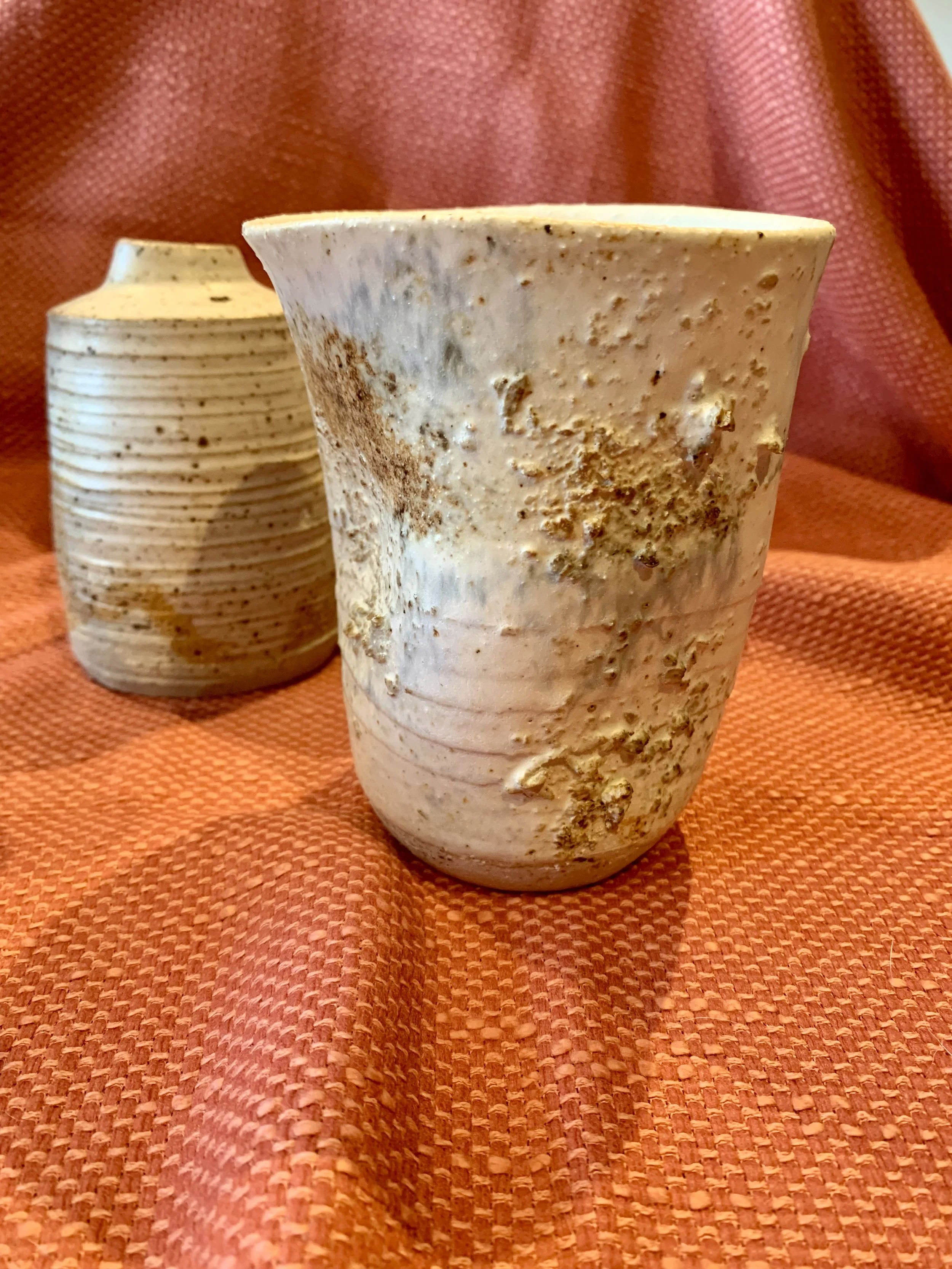 Thrown and altered stoneware vase with texture and oxide colouring and thrown and textured narrow-necked stoneware vase