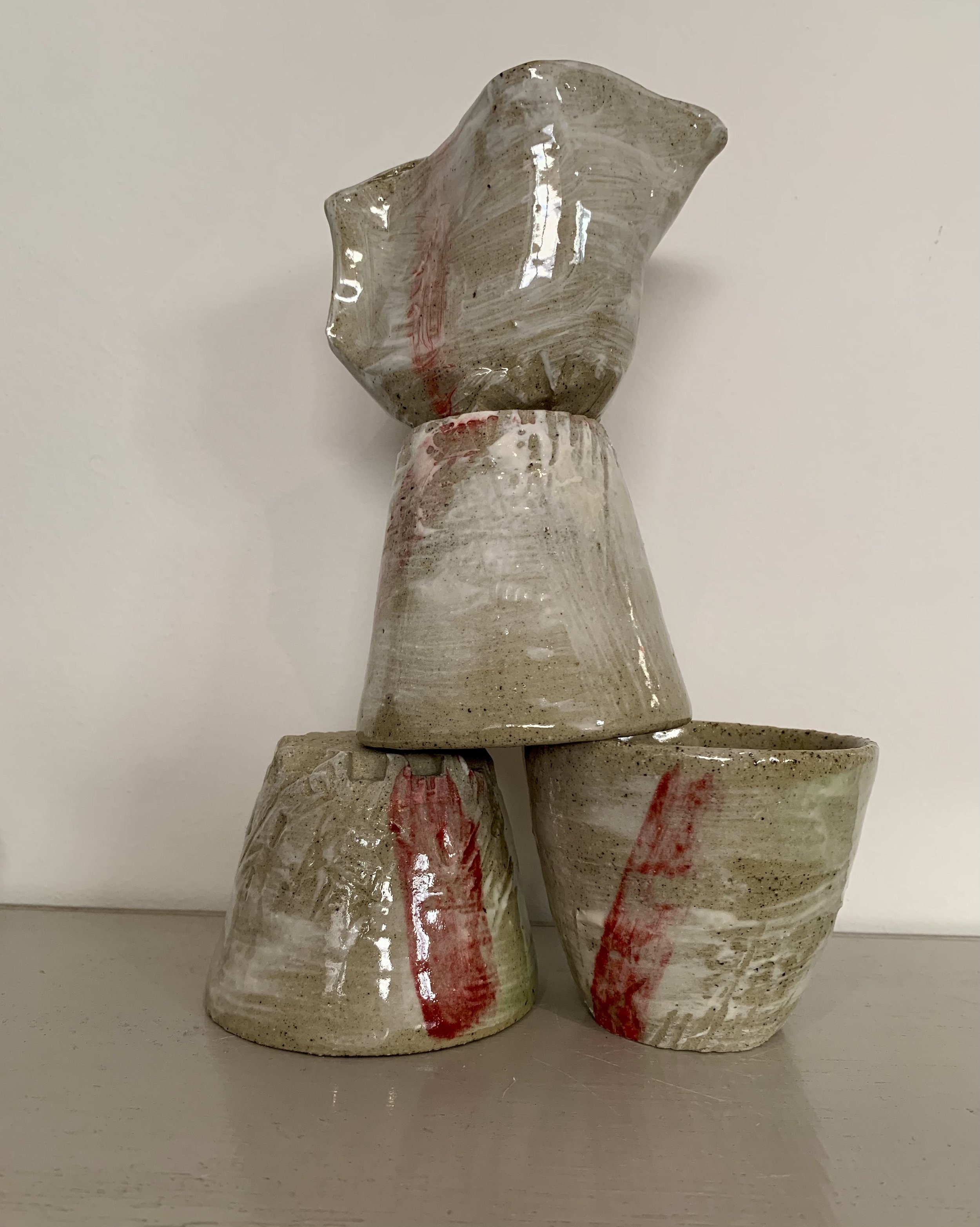 Three slip decorated and carved stoneware tumblers and pourer