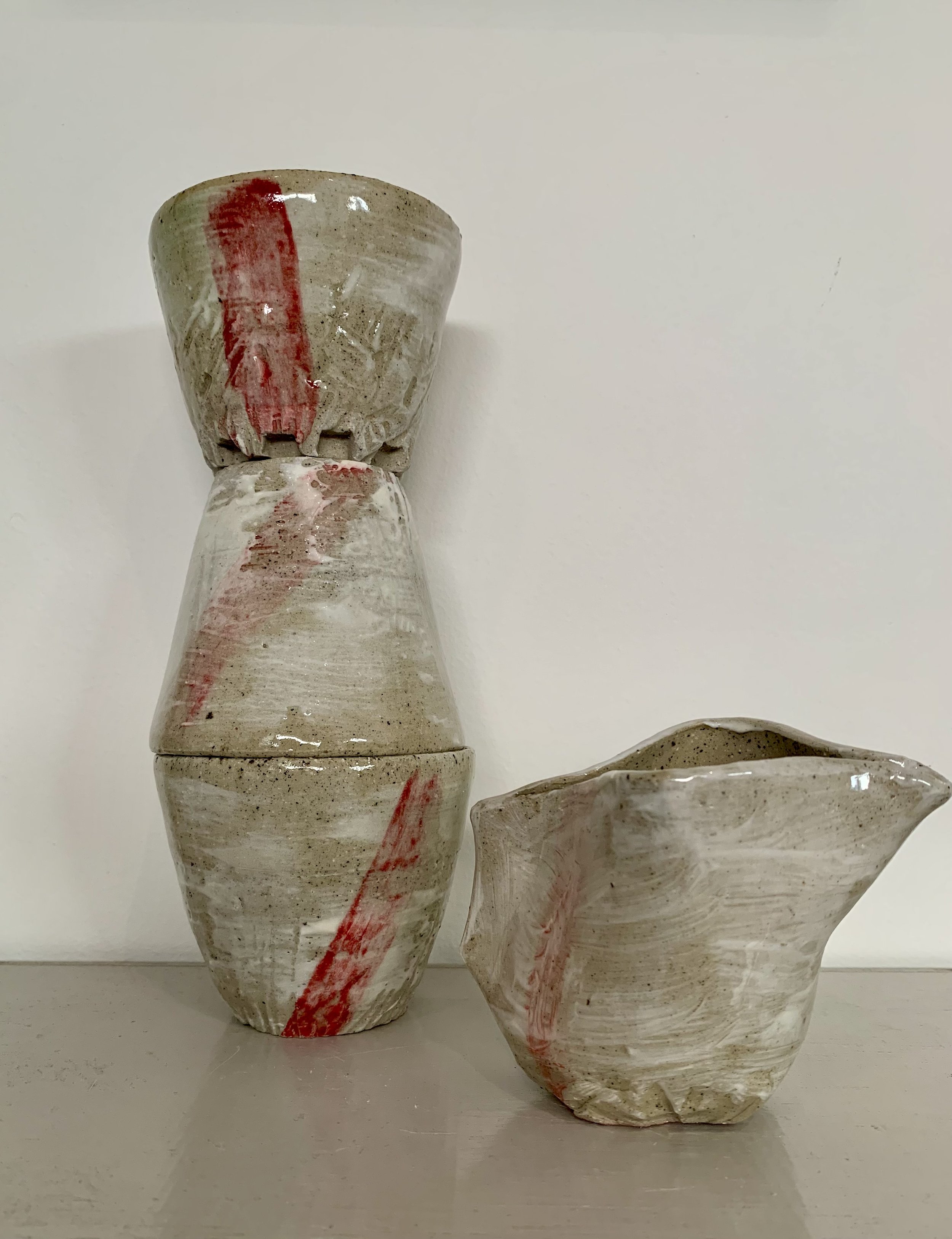 Three slip decorated and carved stoneware tumblers and pourer