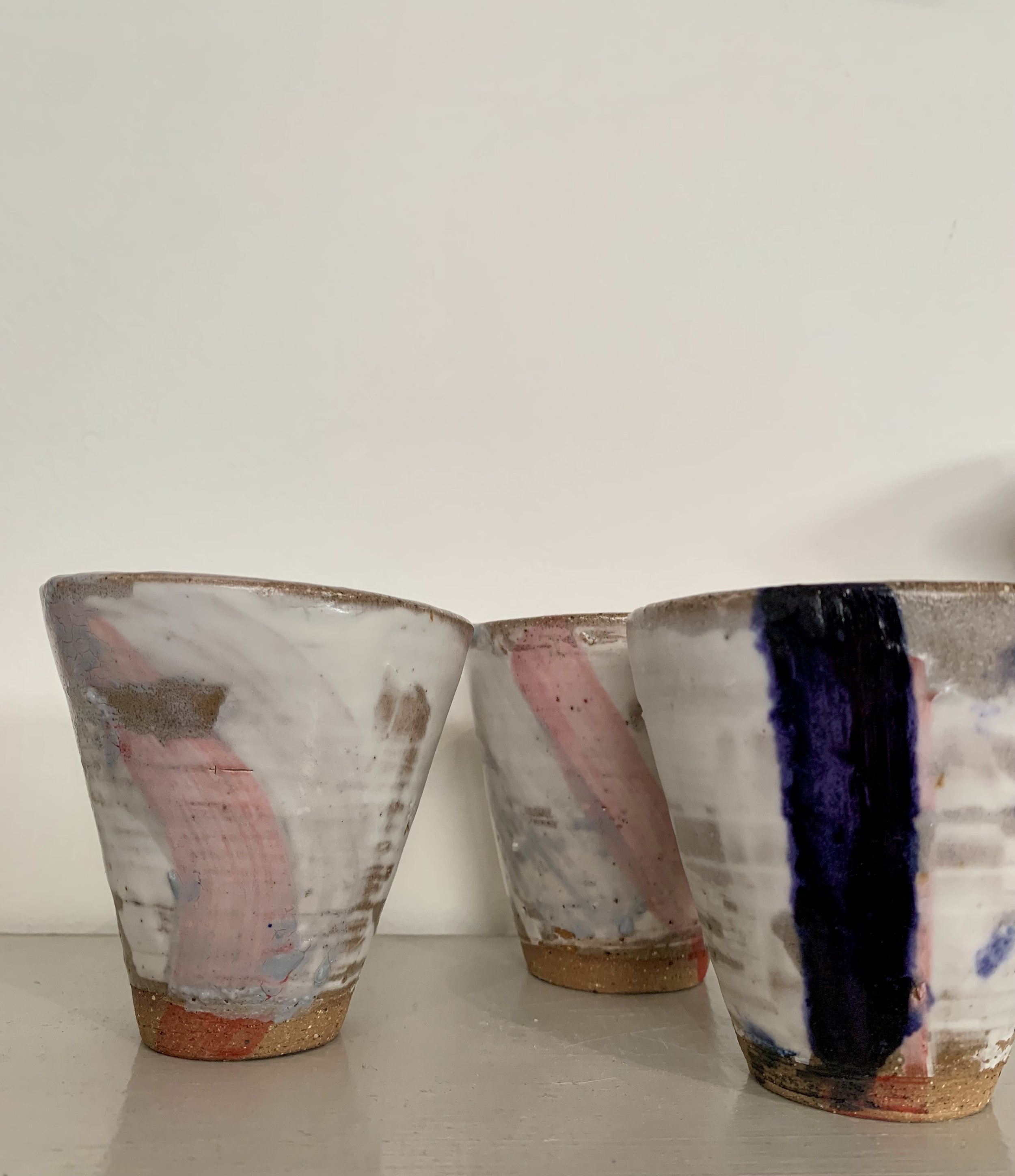 Three slip decorated stoneware tumblers