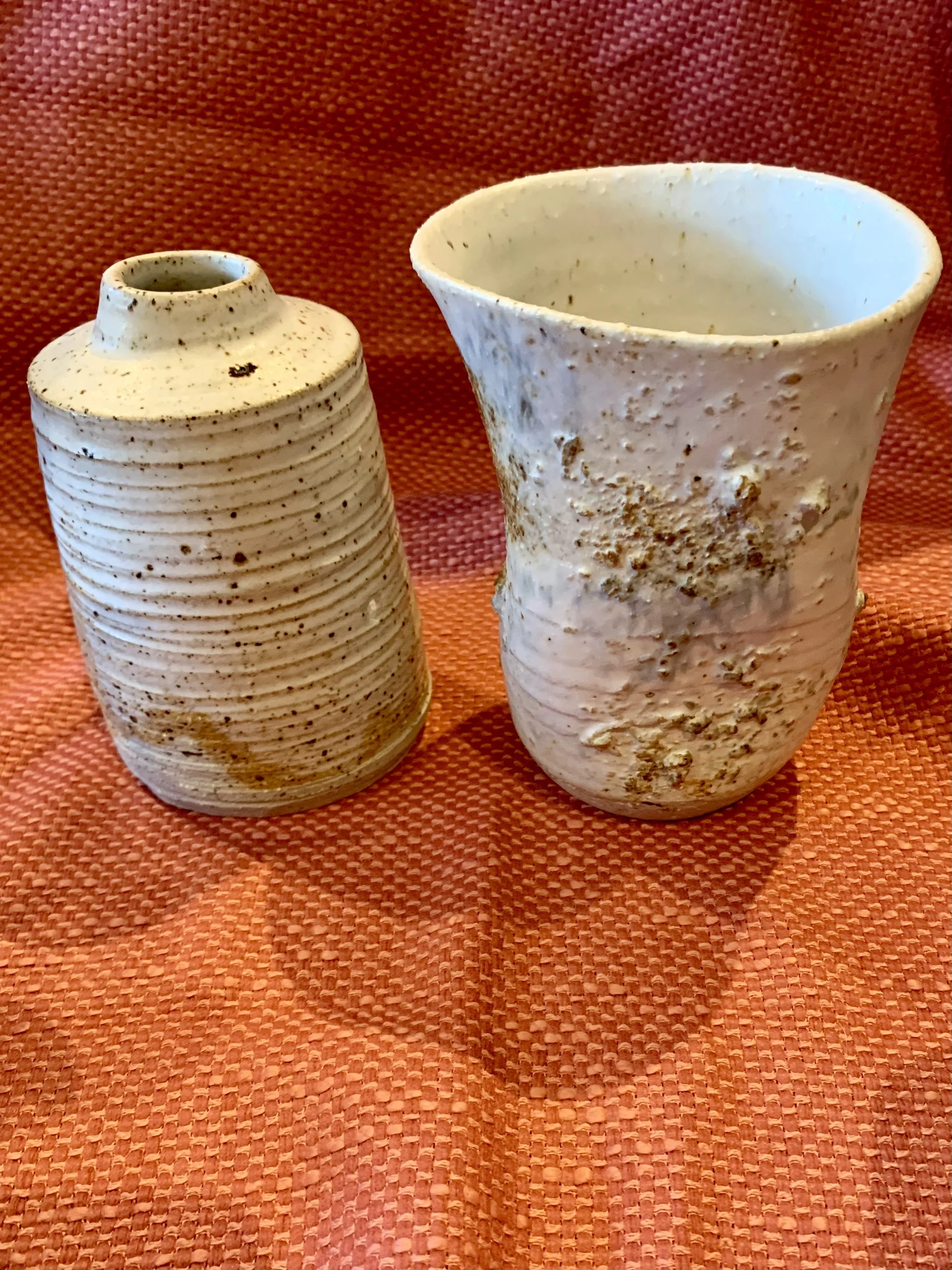 Thrown and altered stoneware vase with texture and oxide colouring and thrown and textured narrow-necked stoneware vase