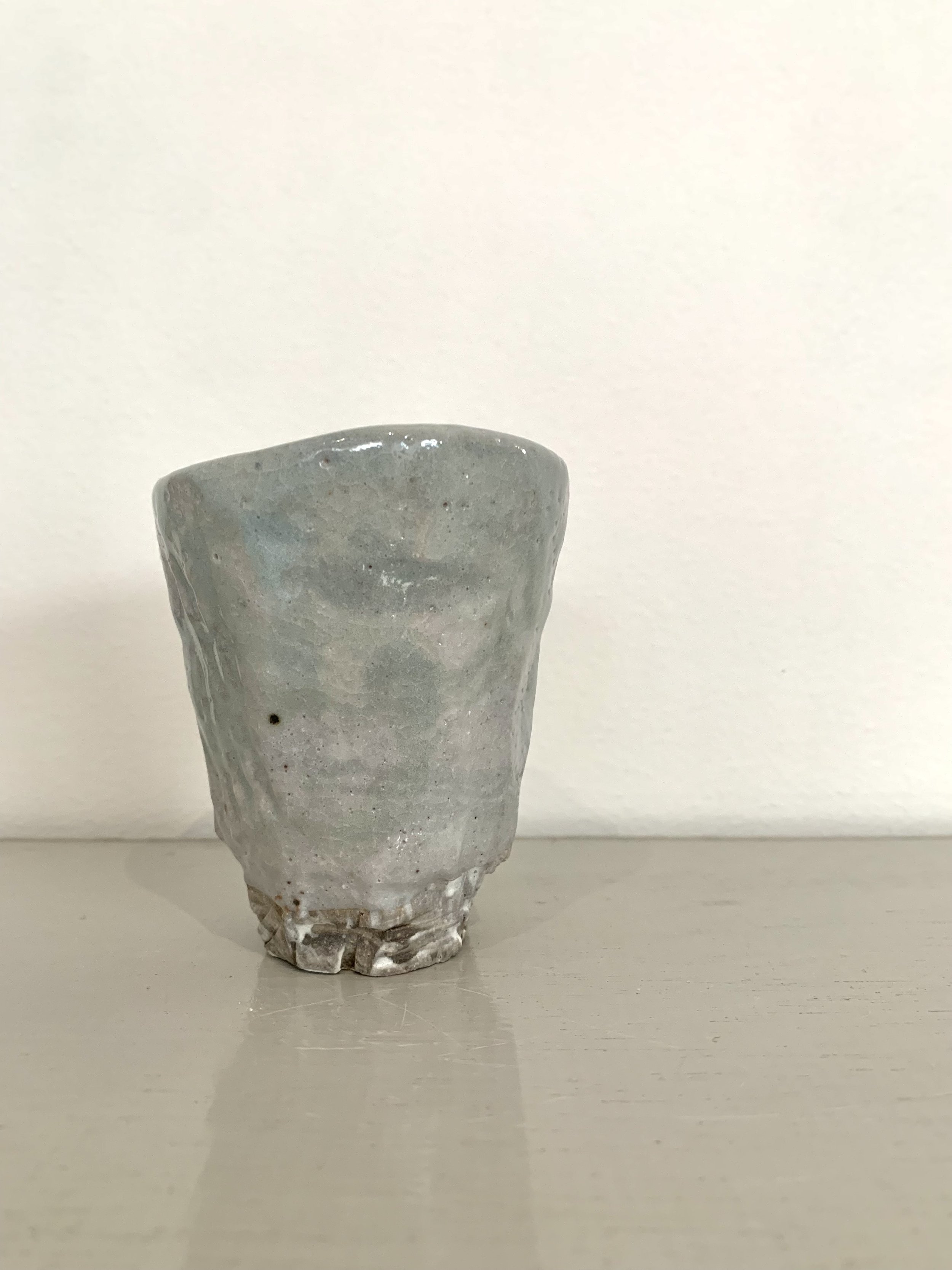 Small carved footed cup, slip with shino and ash glazes