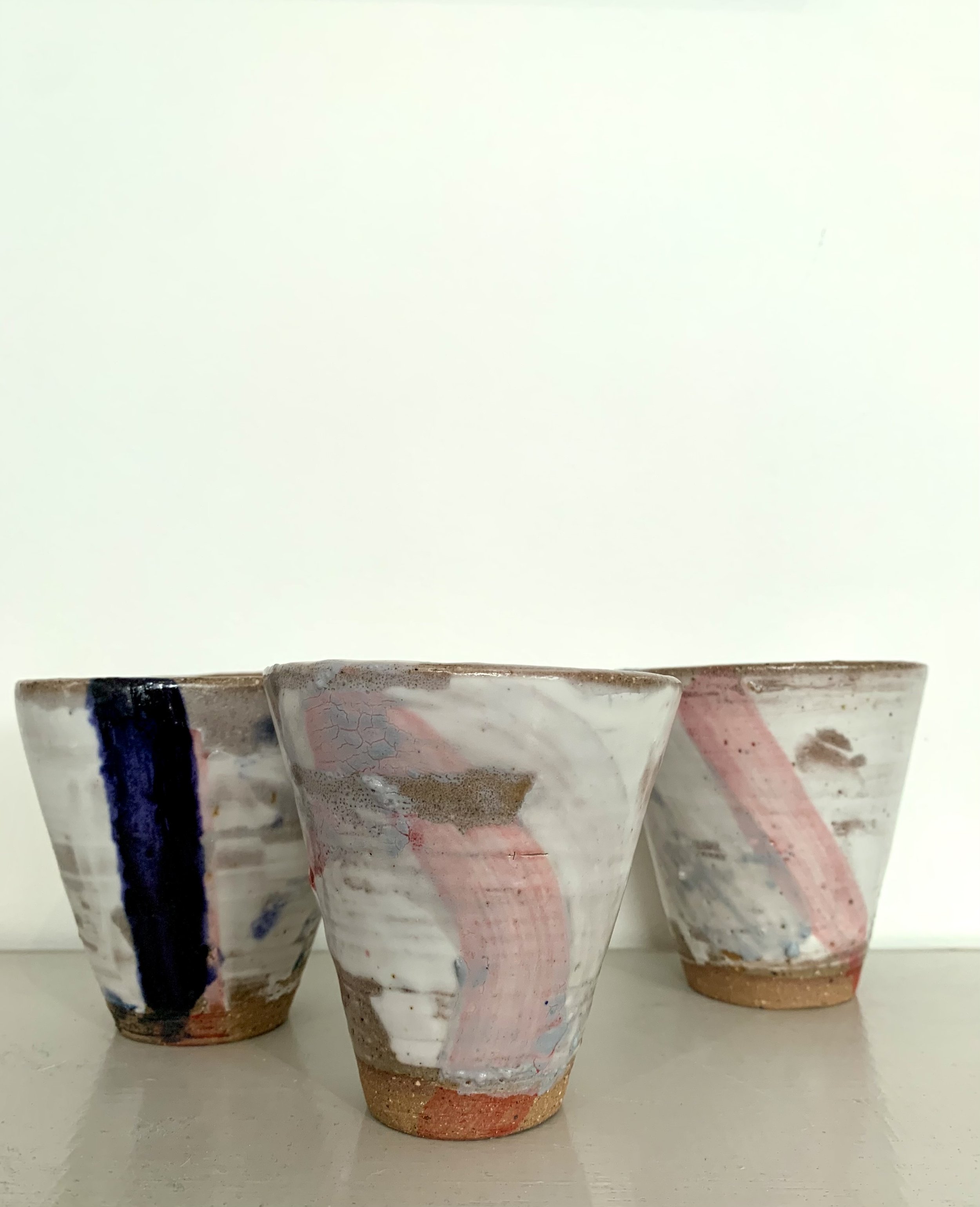 Three slip decorated stoneware tumblers