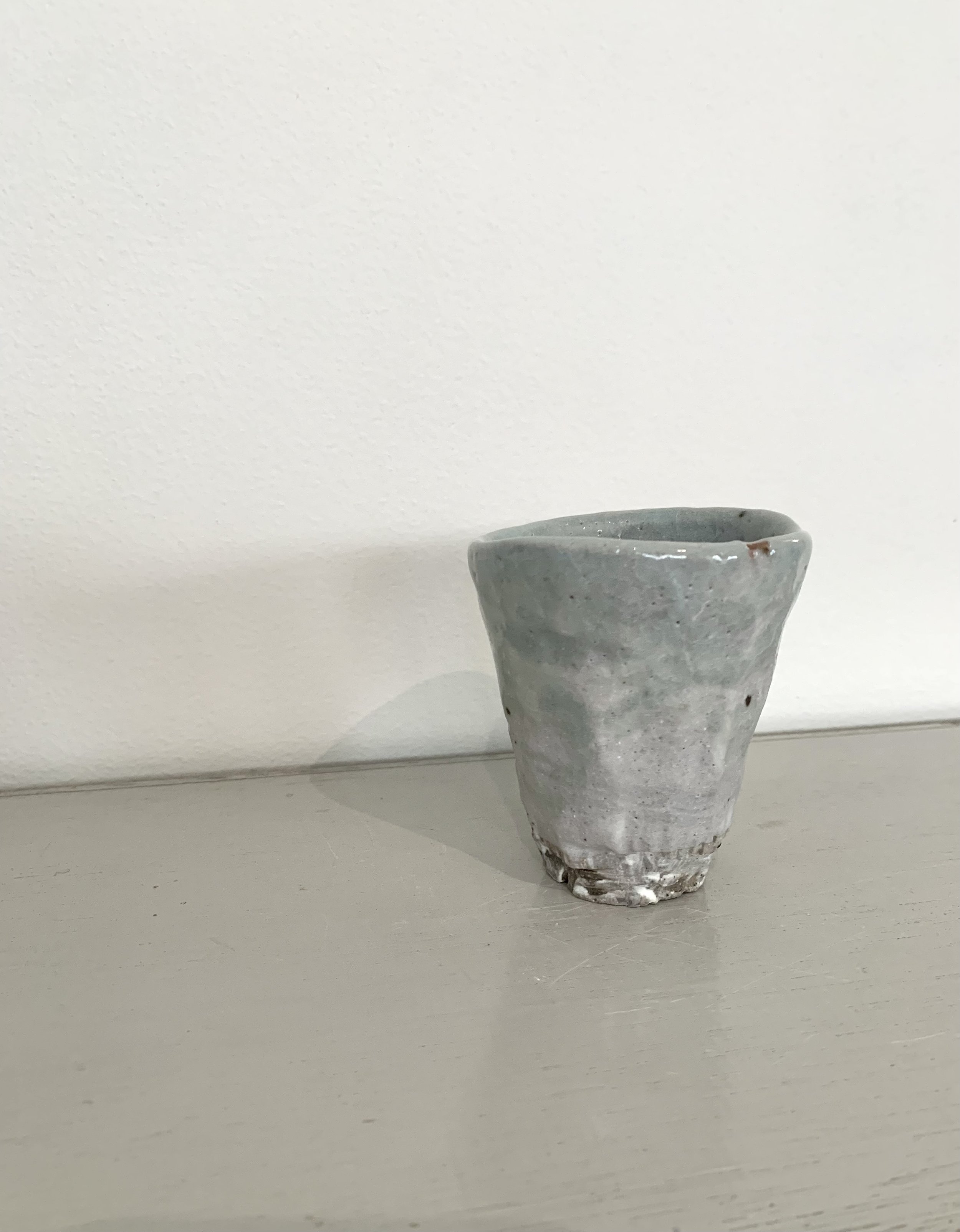 Small carved footed cup, slip with shino and ash glazes