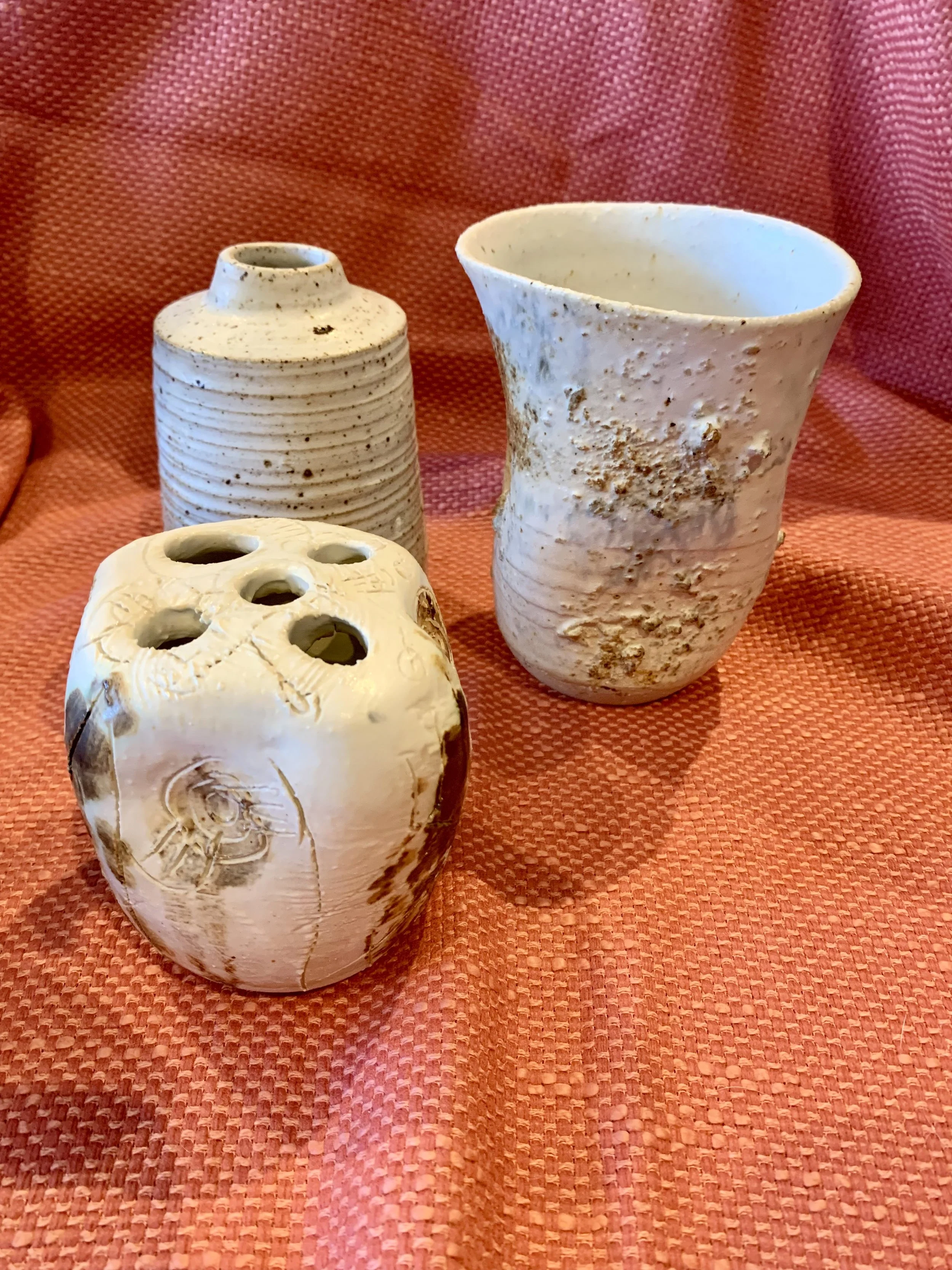 Thrown and altered stoneware vase with texture and oxide colouring, thrown and textured narrow-necked stoneware vase, and thrown and altered stem vase with texture and oxide colouring.