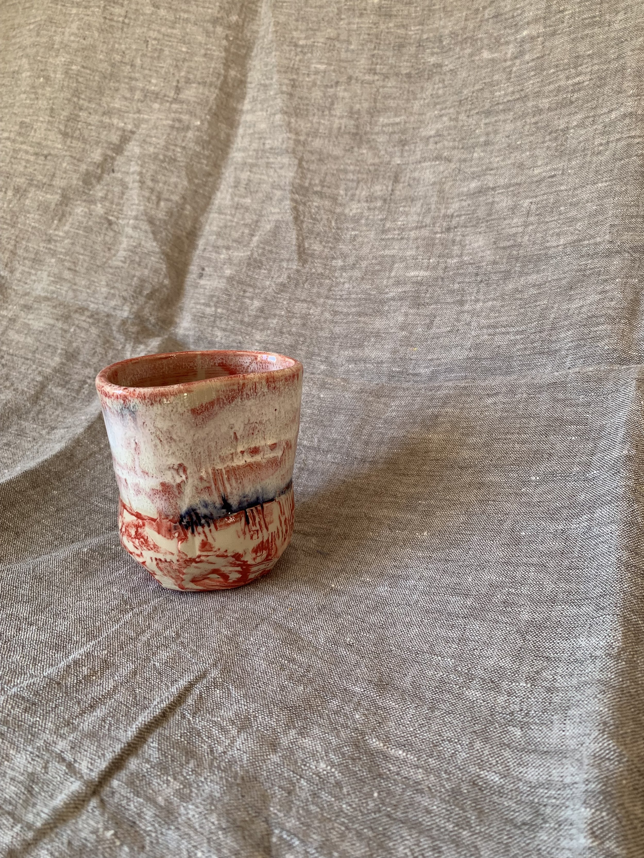 Small carved stoneware tumbler decorated with red slip and cobalt oxide