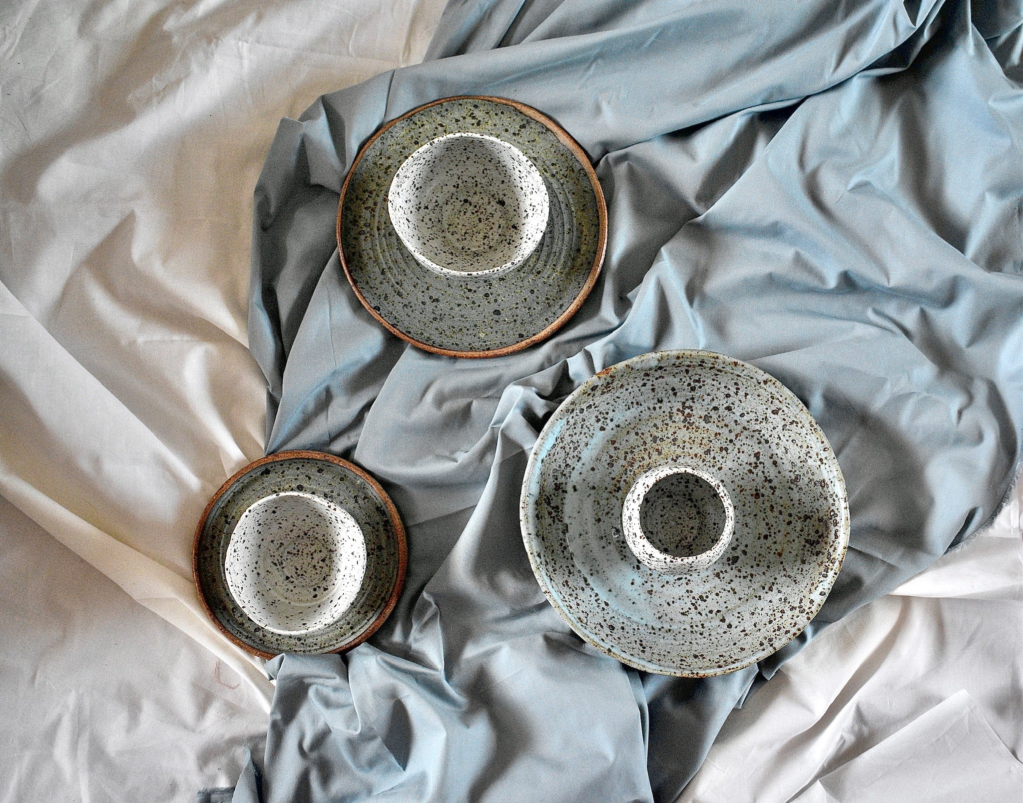 Side plate, dinner plate, and serving dish with three small footed bowls, reduction fired stoneware