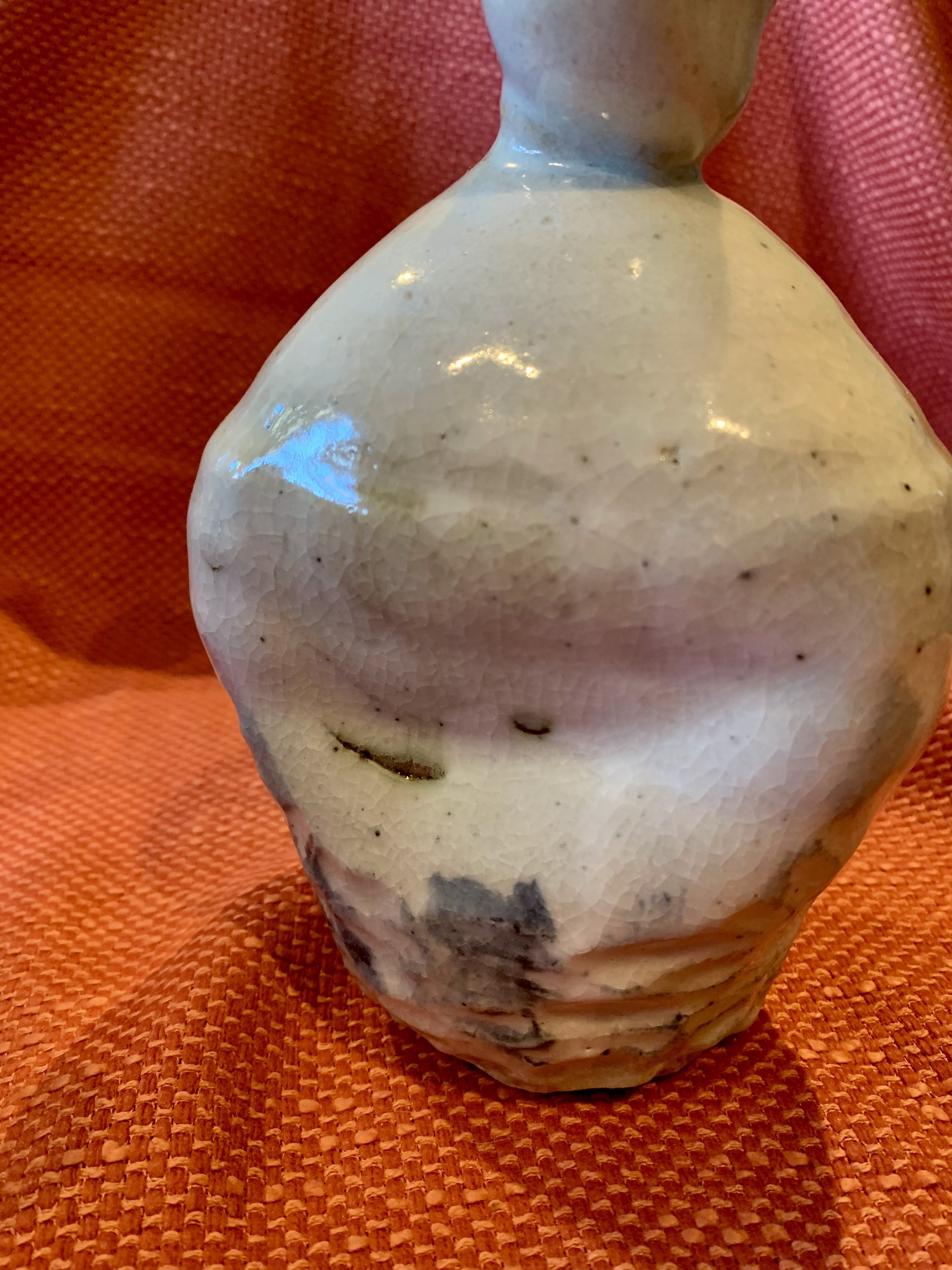 Detail of stoneware bottle, slip and oxide decoration over shino glaze with ash glazed neck
